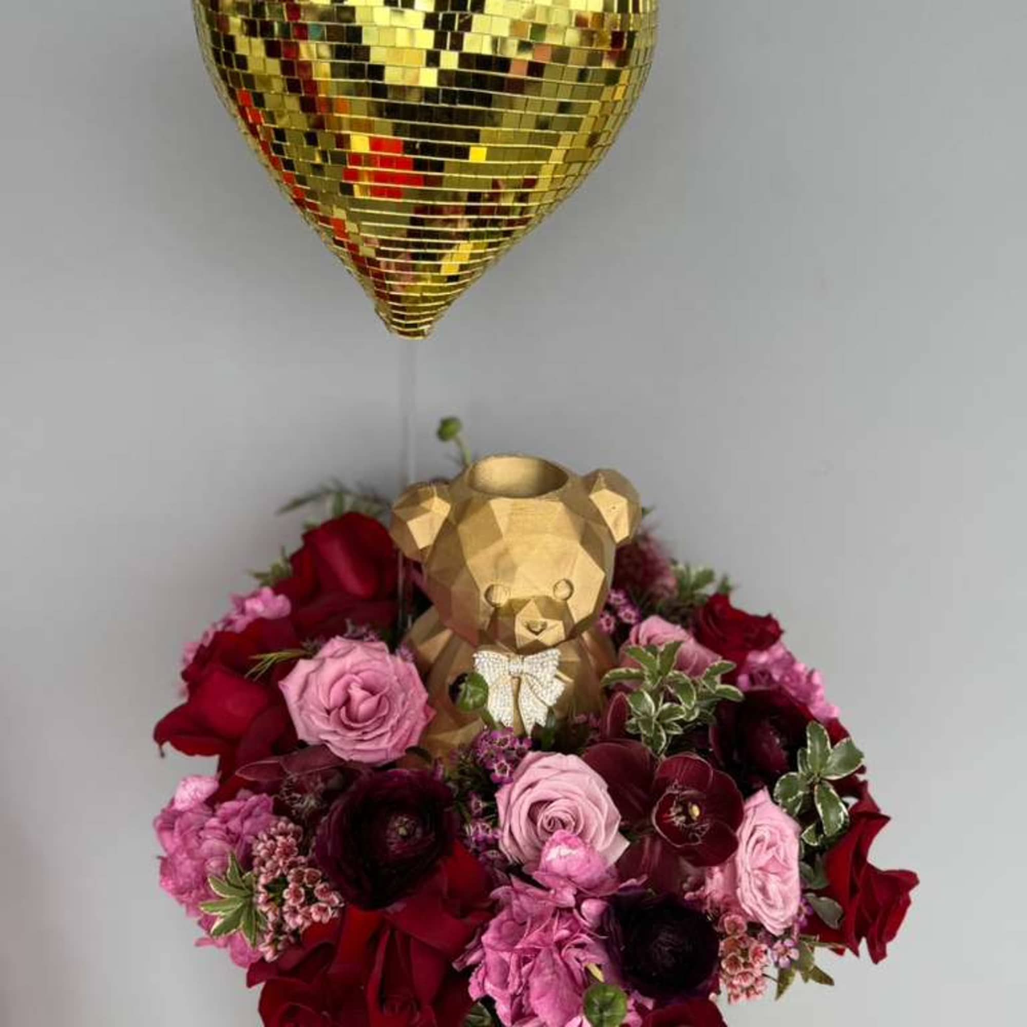 A stunning gold bear, heart and base filled with lush flowers- the