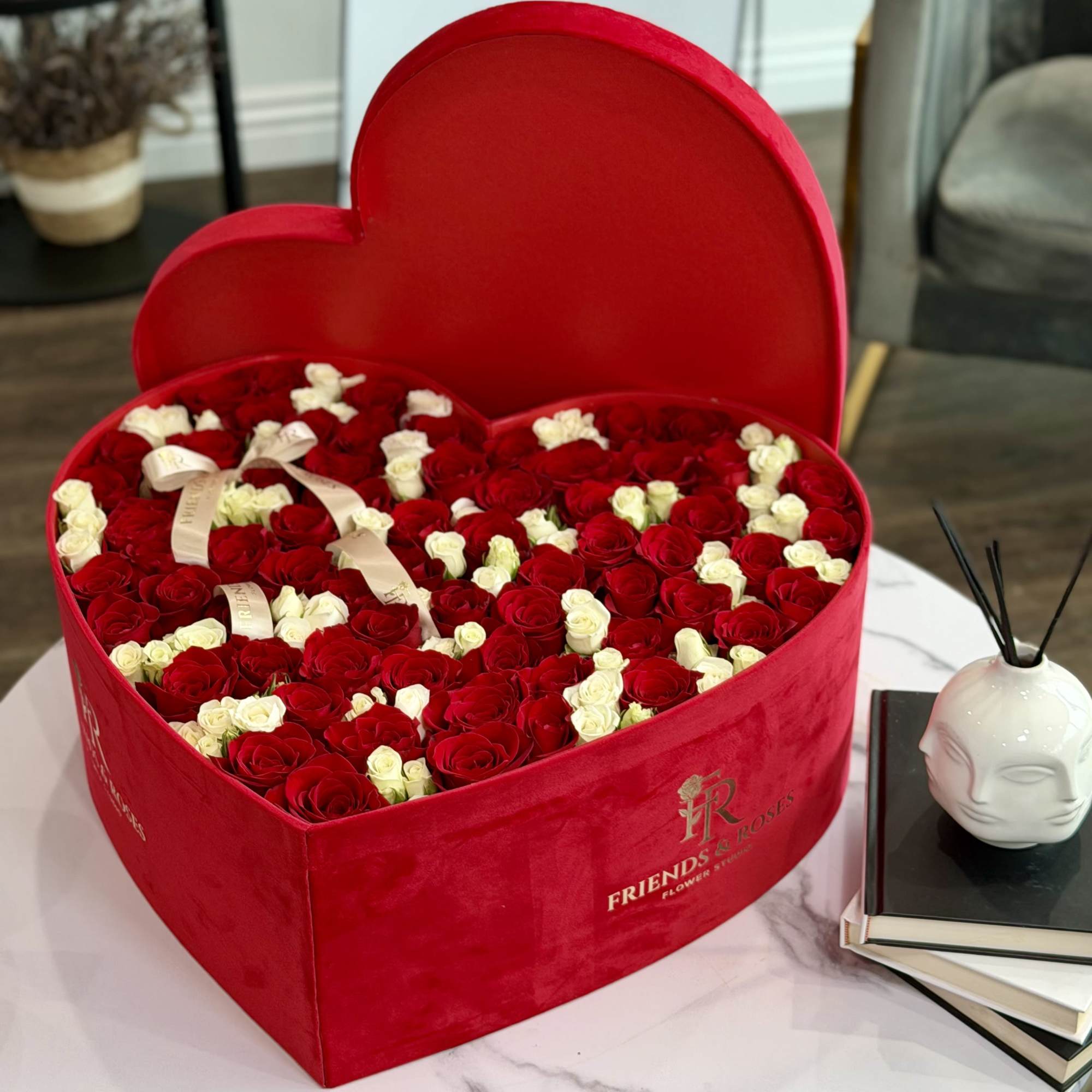 A large heart of velvety red and delicate ivory roses, designed to