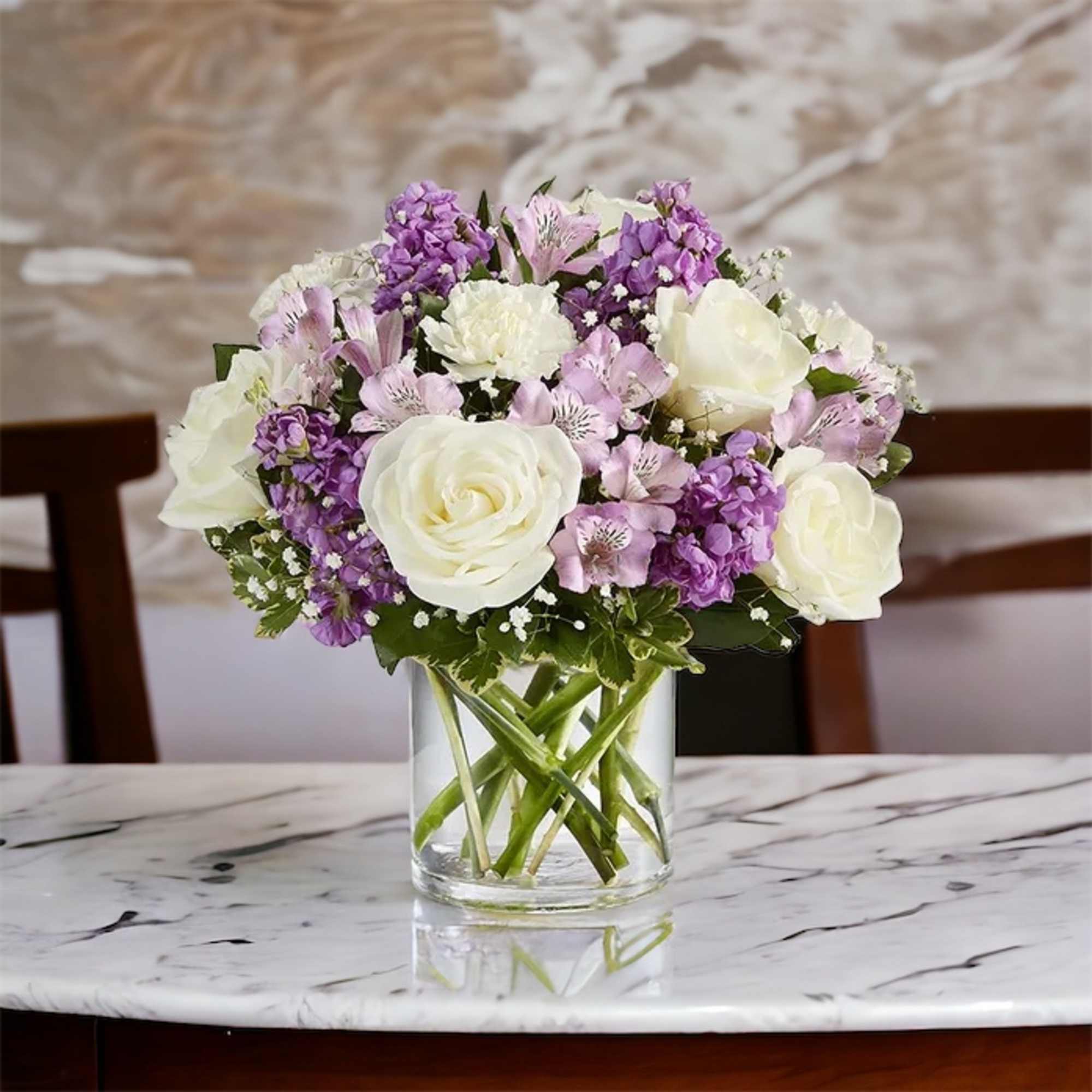 White roses, white carnations, lavender Astro, purple stock, baby&rsquo; breath and greenery