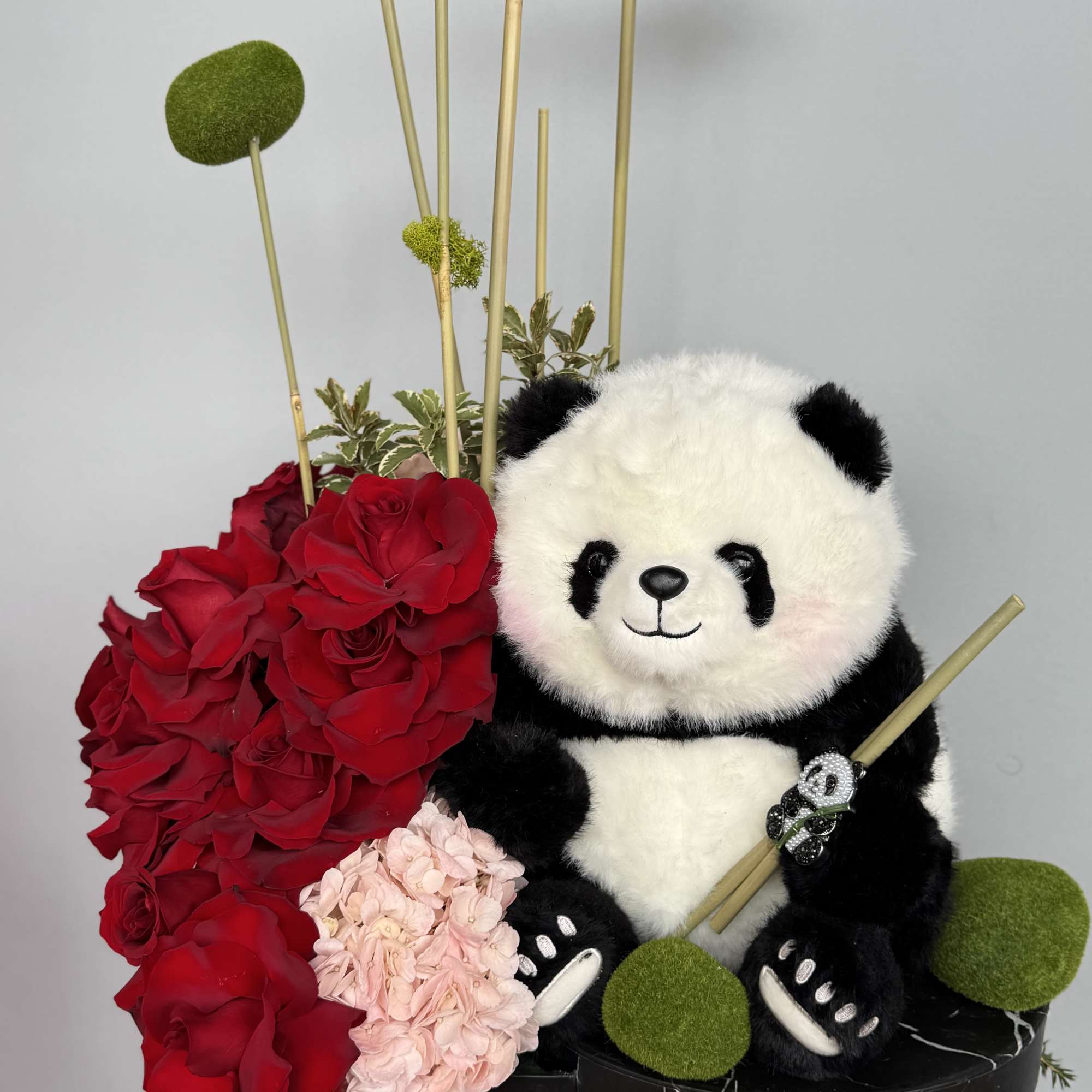 A serene mix of bamboo, pink hydrangeas, red roses and mossy green