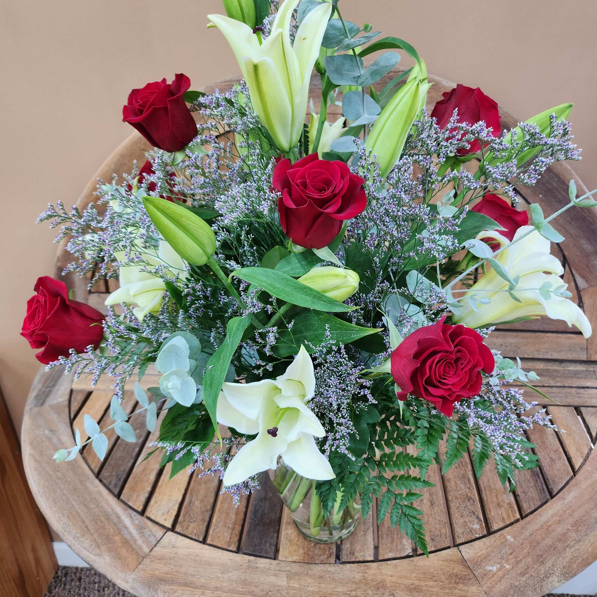 A mixture of red roses and white lilies with fifiller and greens