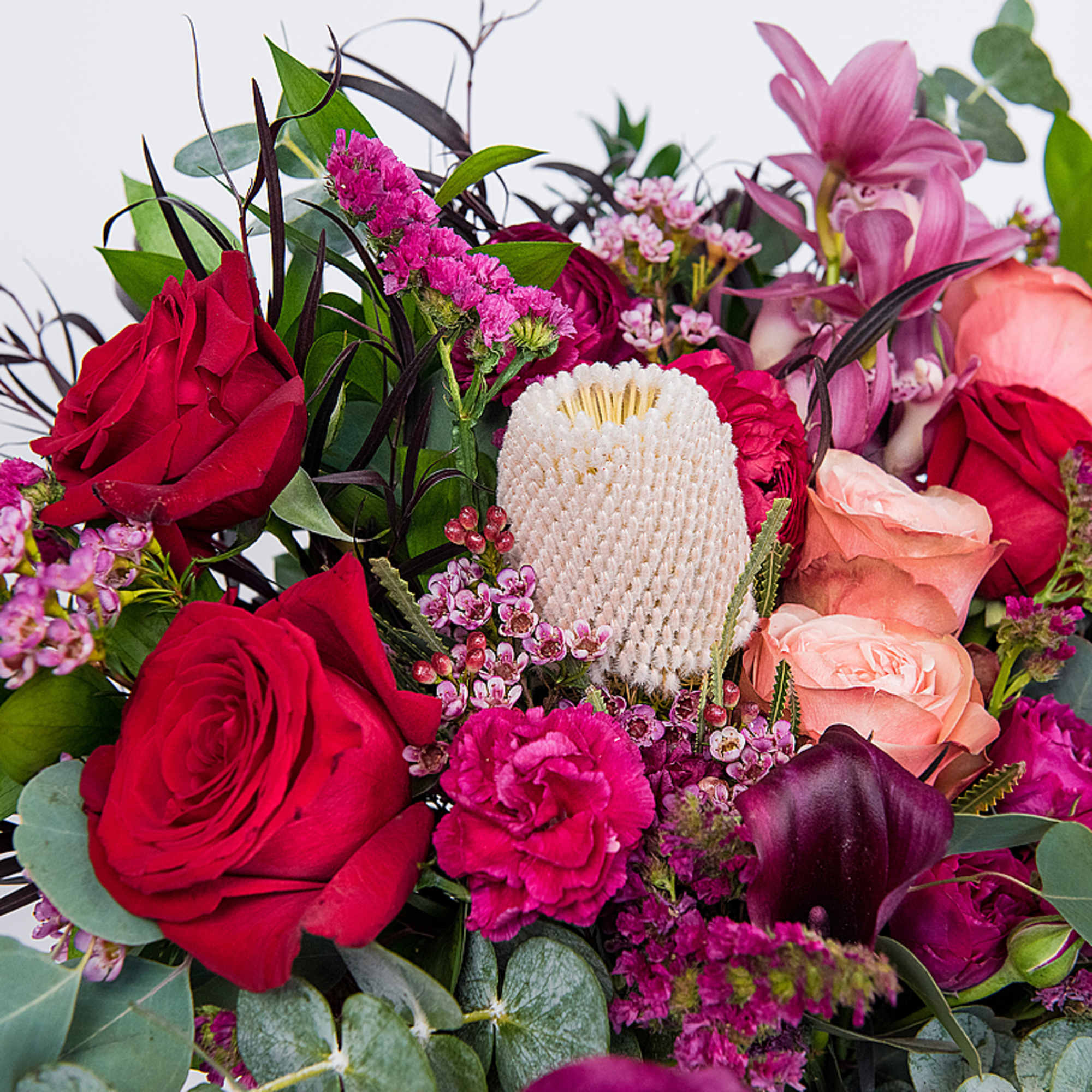 A romantic seasonal Valentine&rsquo;s Day arrangement featuring lush red and blush roses