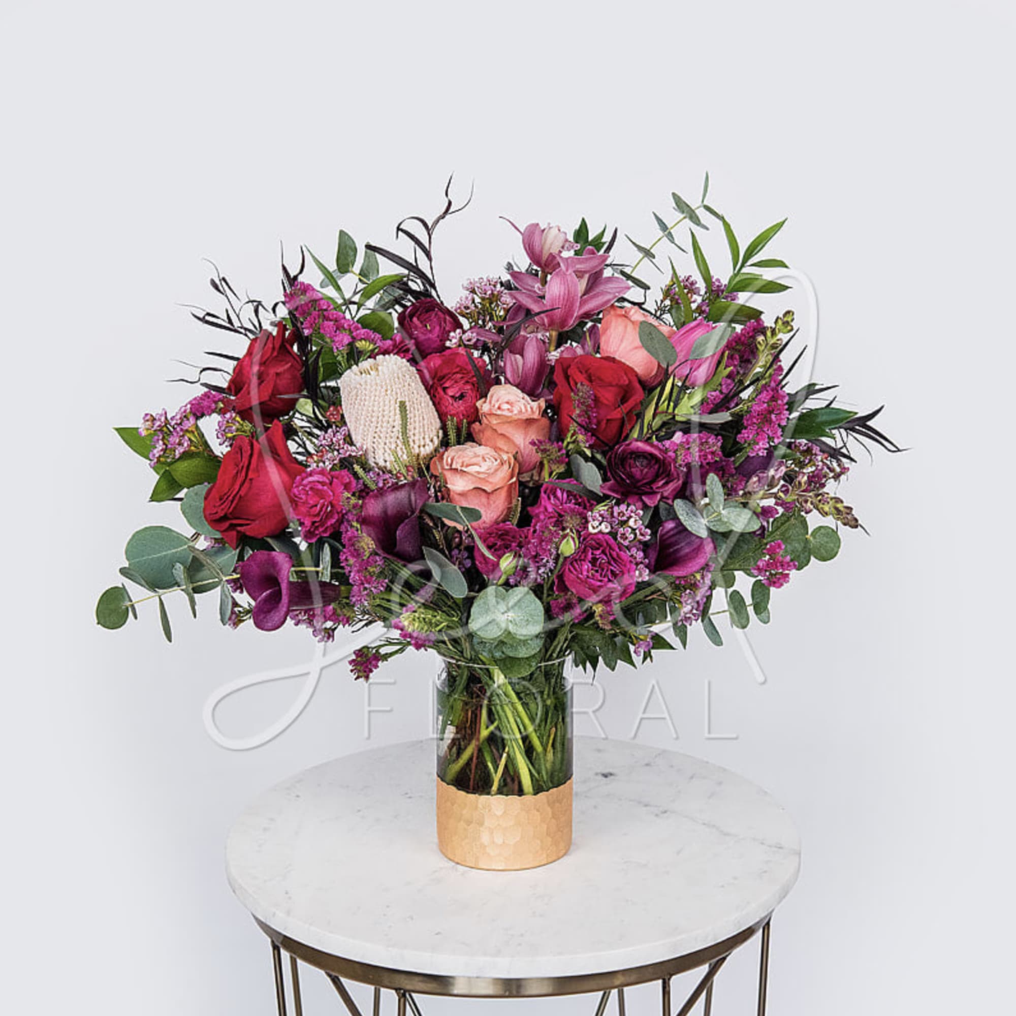 A romantic seasonal Valentine&rsquo;s Day arrangement featuring lush red and blush roses