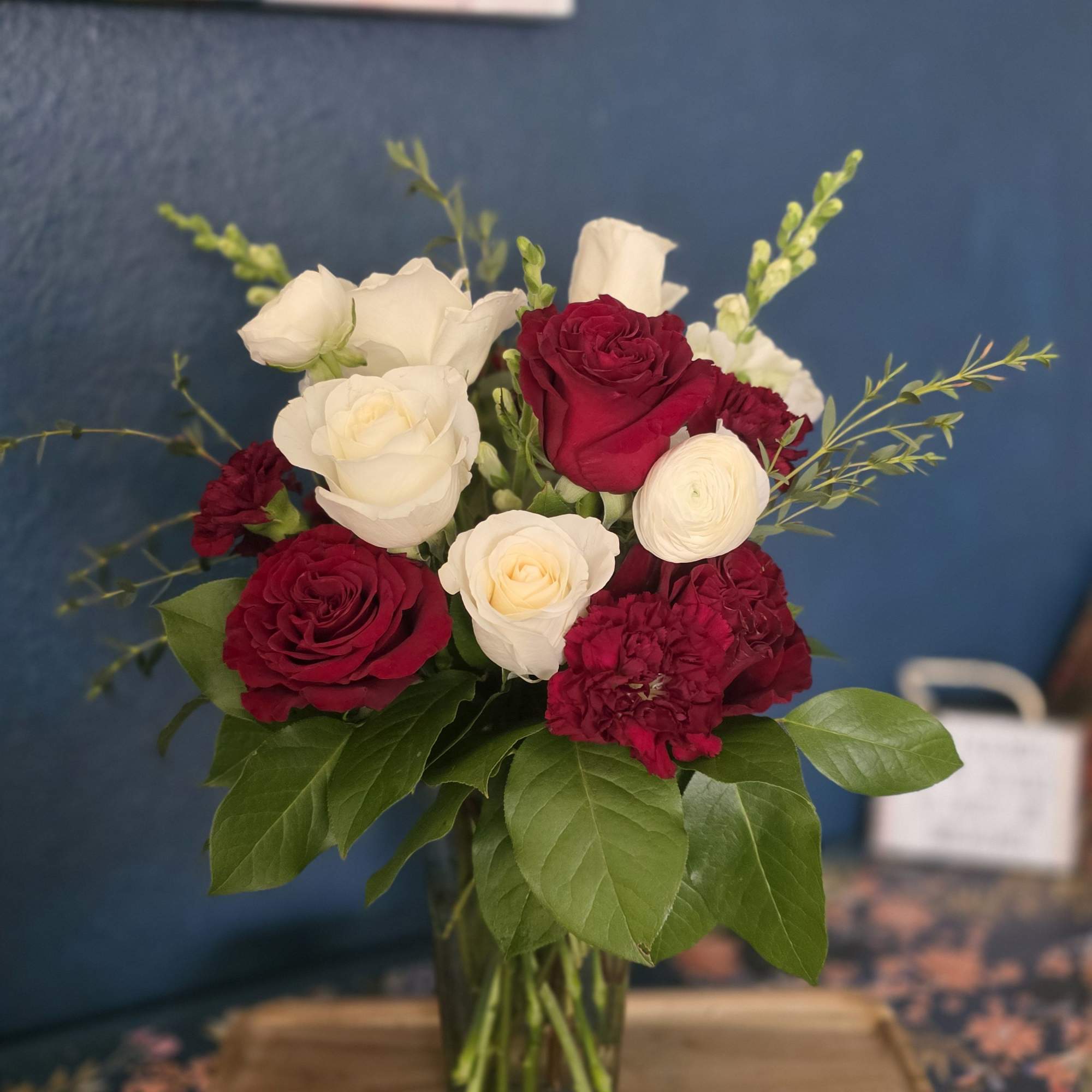 The Burgundy Beauty is a rich design with snap dragons, white roses