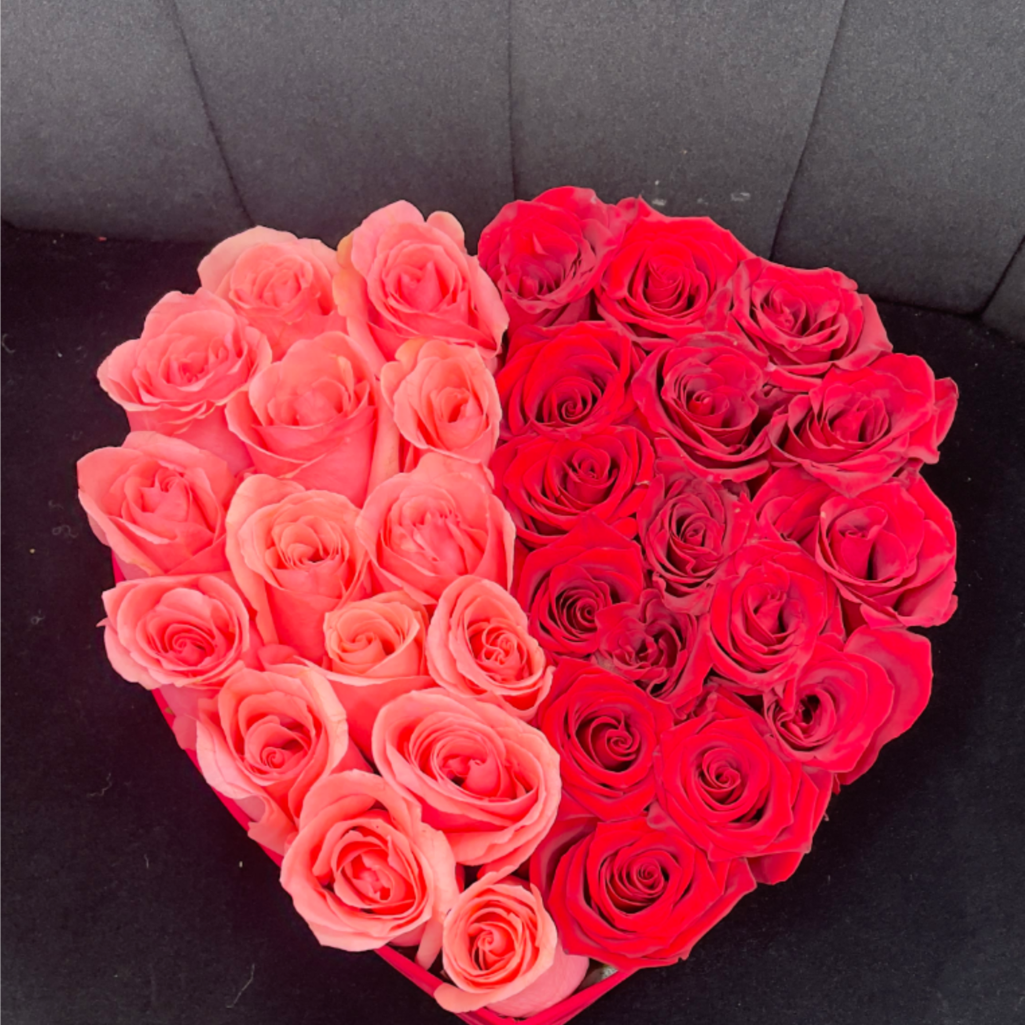 A striking heart-shaped arrangement featuring deep red roses paired with soft pink