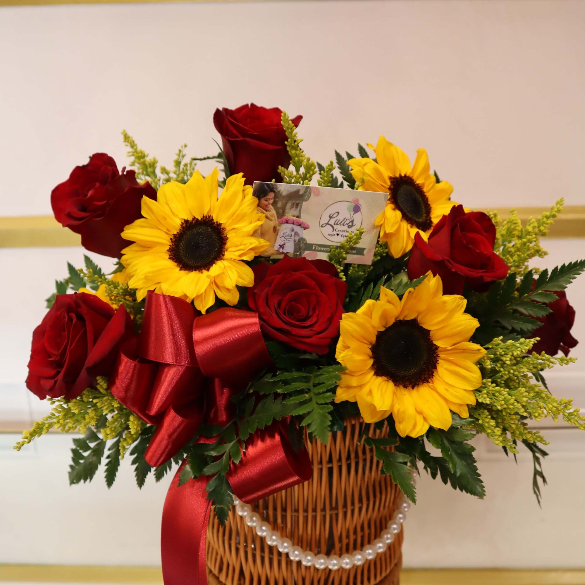 This beautiful cylinder comes with red roses, sunflowers, and assorted filler. 