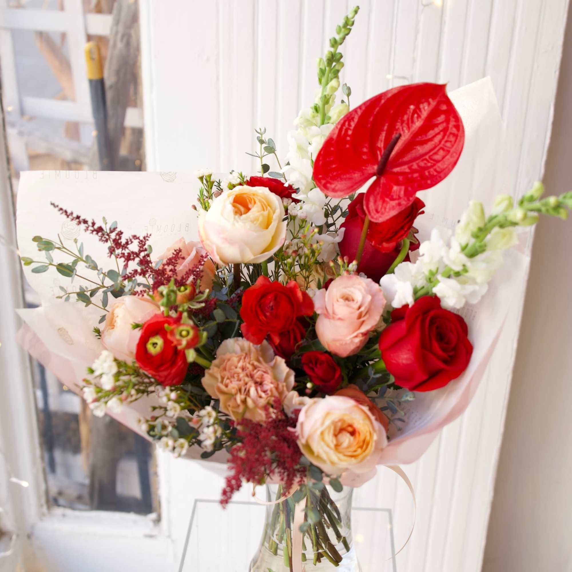 This exquisite bouquet, features velvety-red roses, exotic Anthuriums and peachy garden roses.
Comes