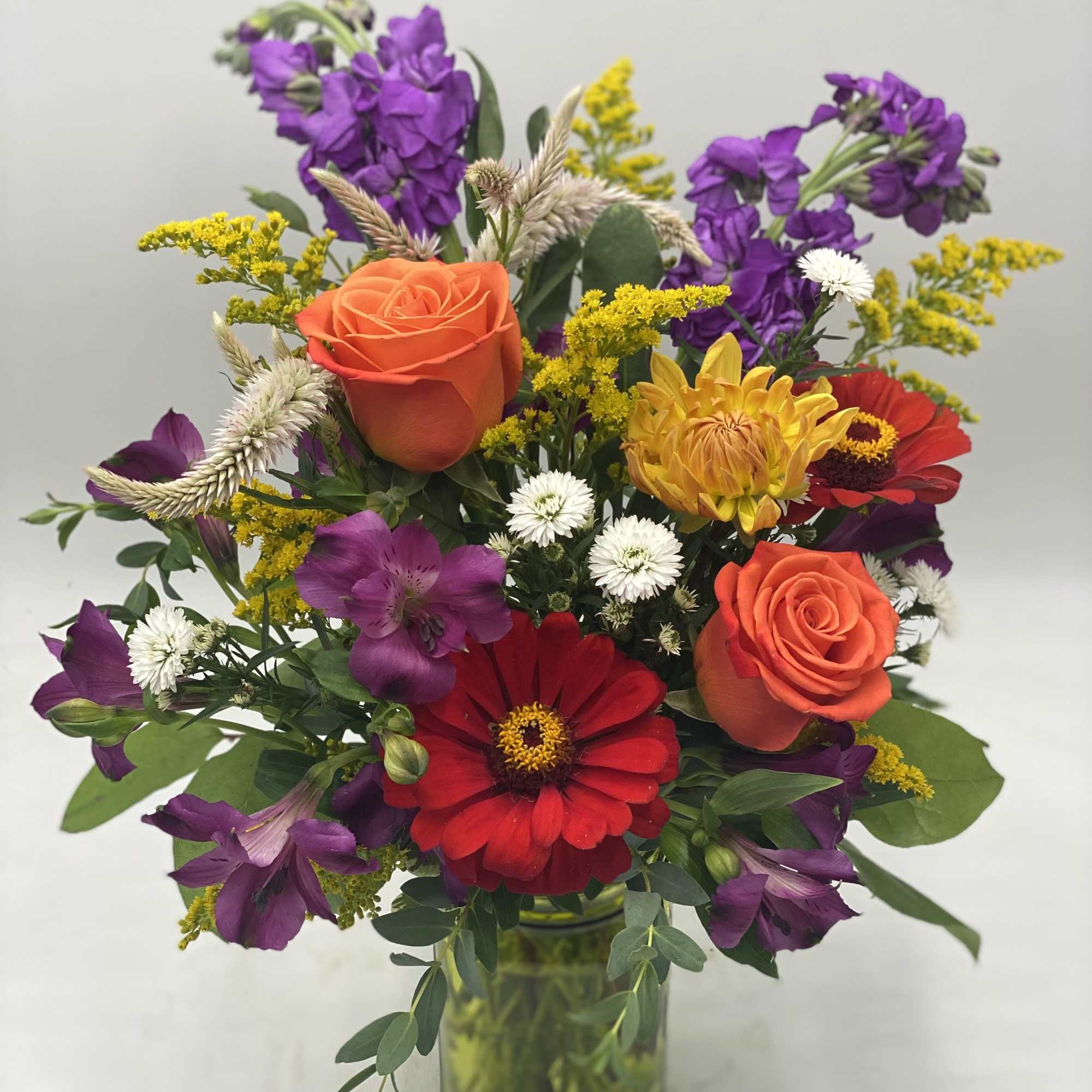 A mix of fresh, seasonal flowers designed in a handled mason jar
