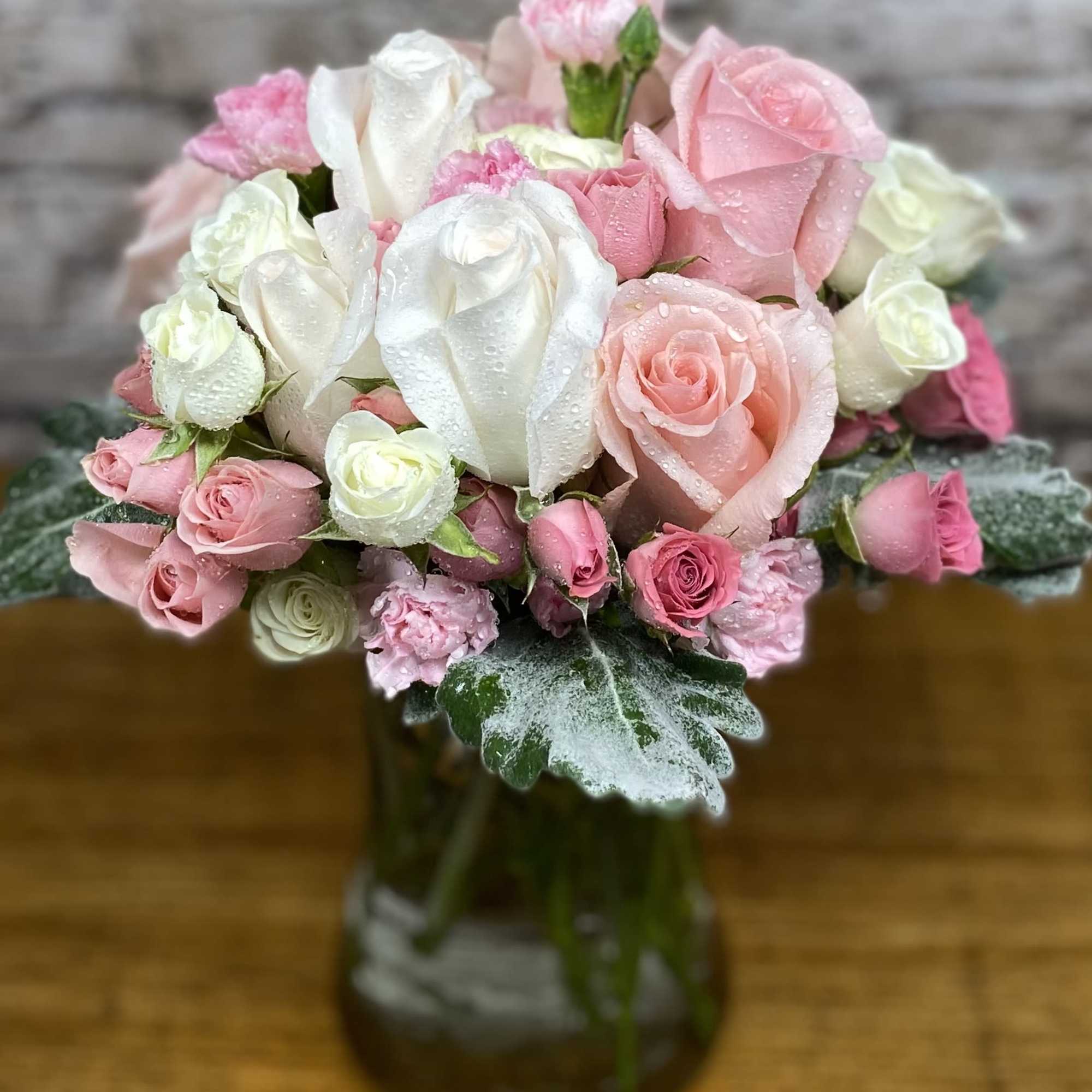 An assortment of pink and white roses, spray roses with complementary flowers