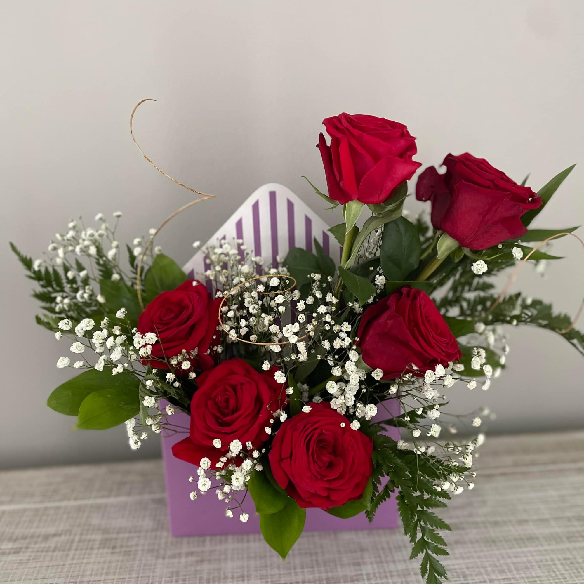 An elegant array of roses and fillers in an envelope style box