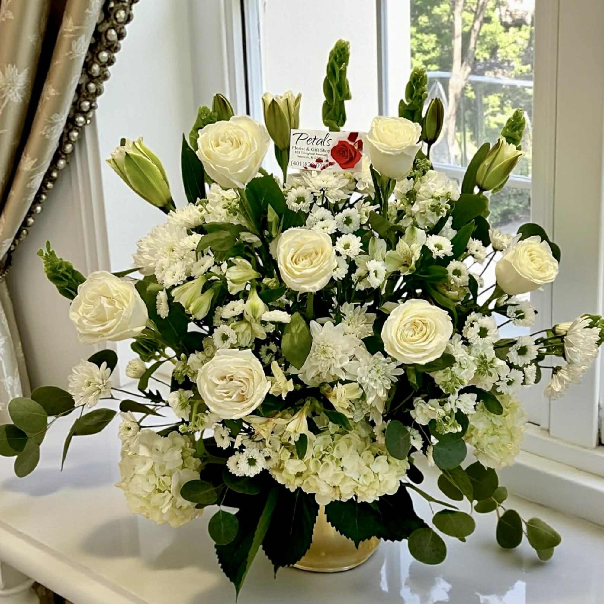  This all-white and green Pure Grace sympathy tribute offers a timeless
