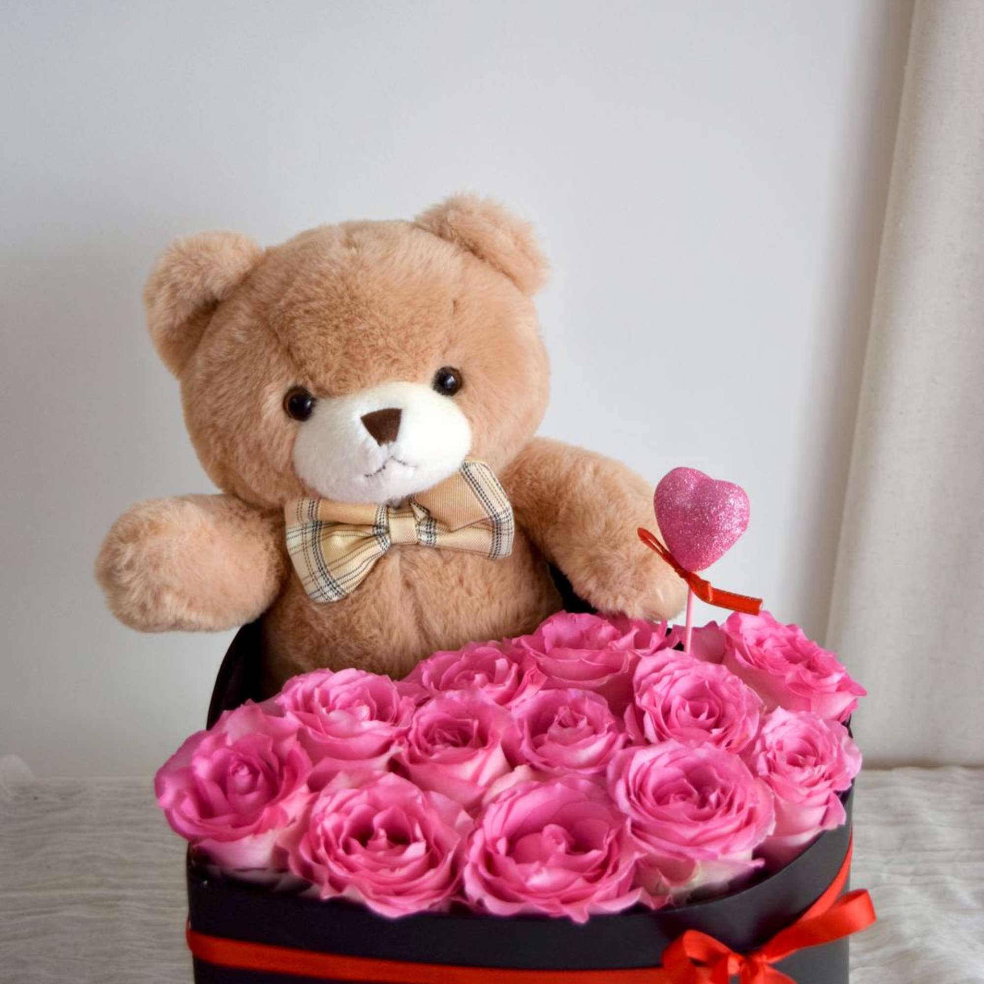 A velvet box filled with fresh roses, paired with a cute teddy