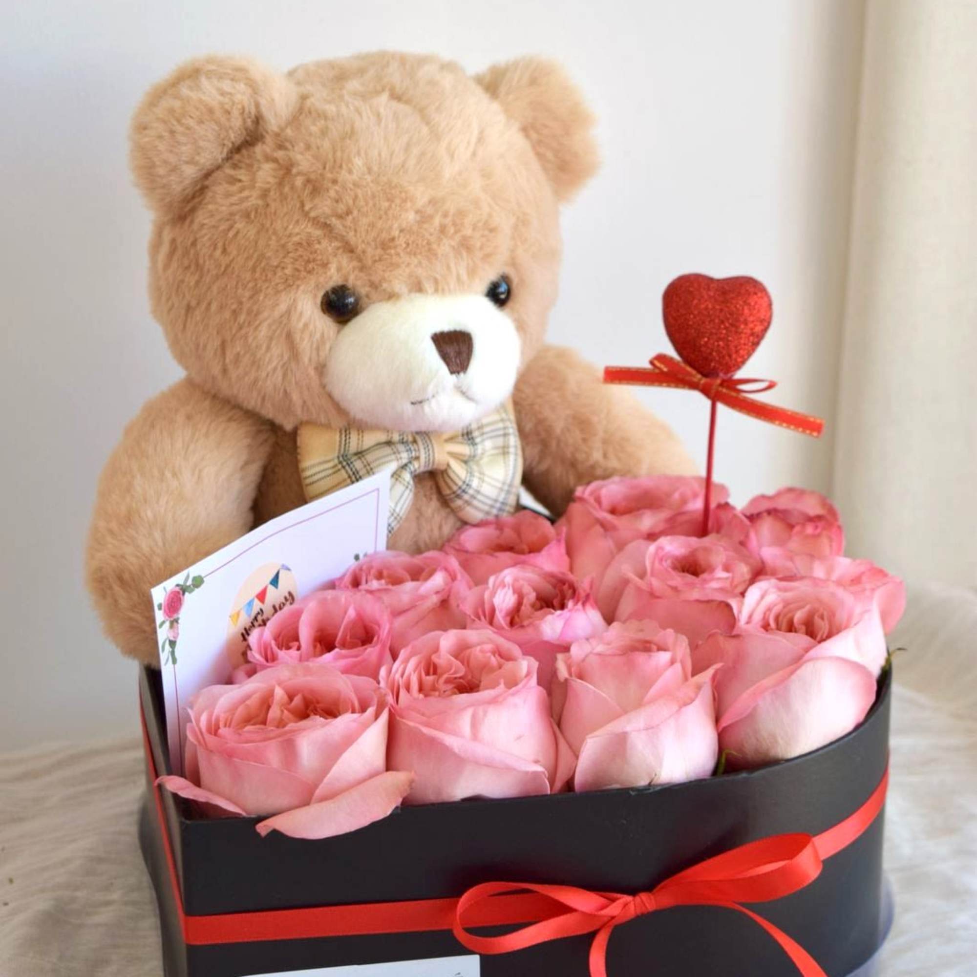 A velvet box filled with fresh roses, paired with a cute teddy