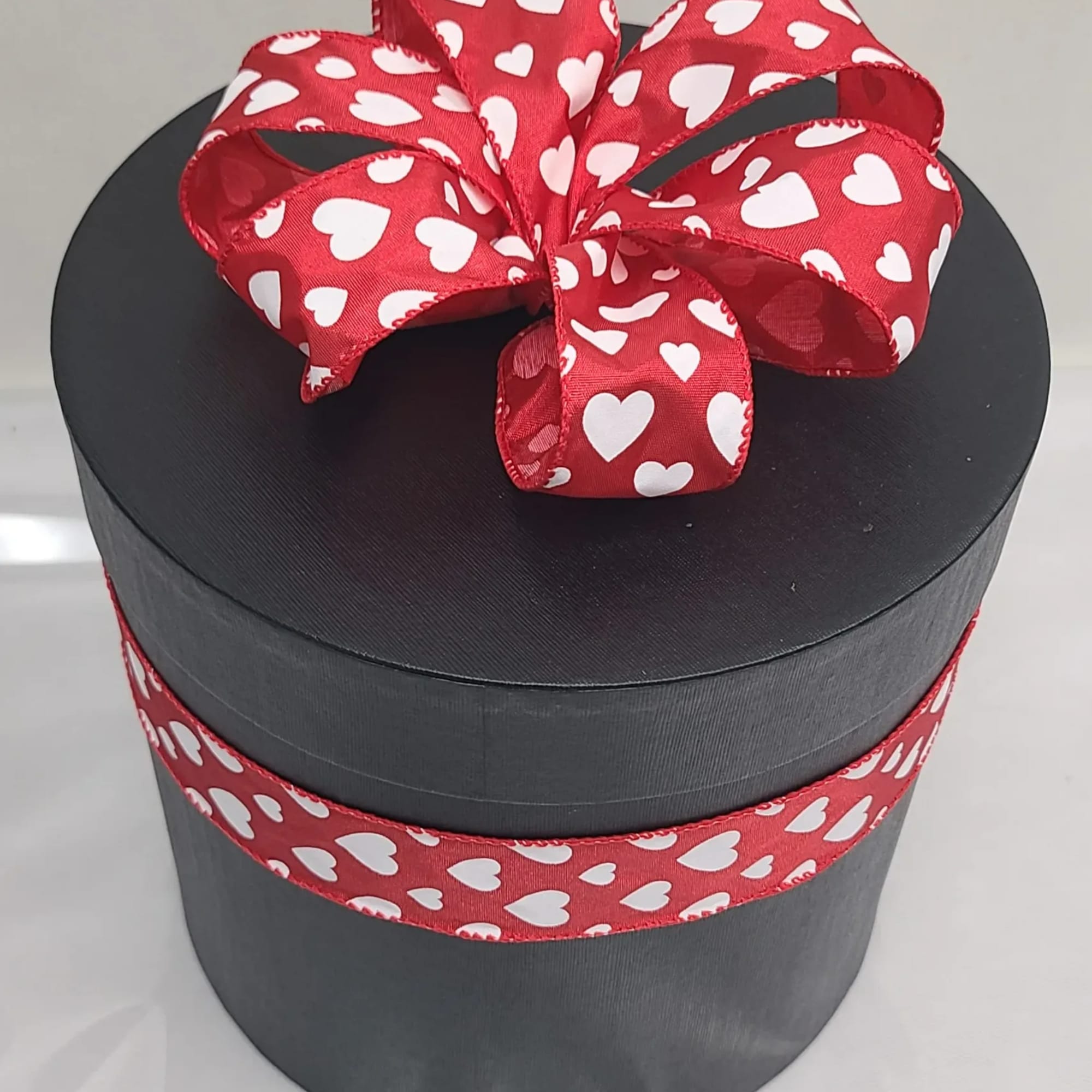 12 preserved roses complimented with preserved baby's breath, in a black hat