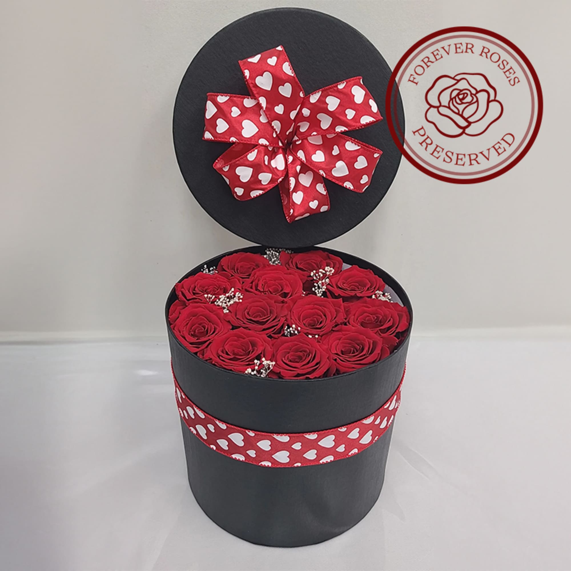 12 preserved roses complimented with preserved baby's breath, in a black hat