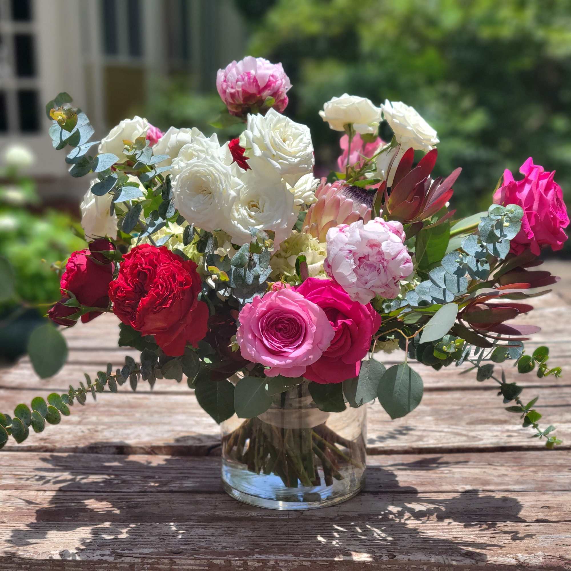 Lush composition in a tonal palette of reds, pinks and whites. Accented