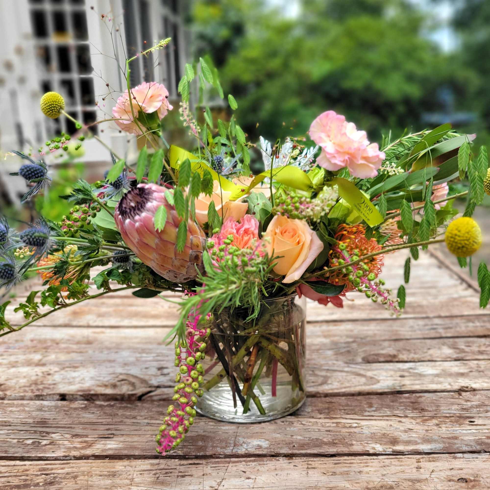 An eclectic beauty containing assorted seasonal blooms, berries, pods and assorted garden