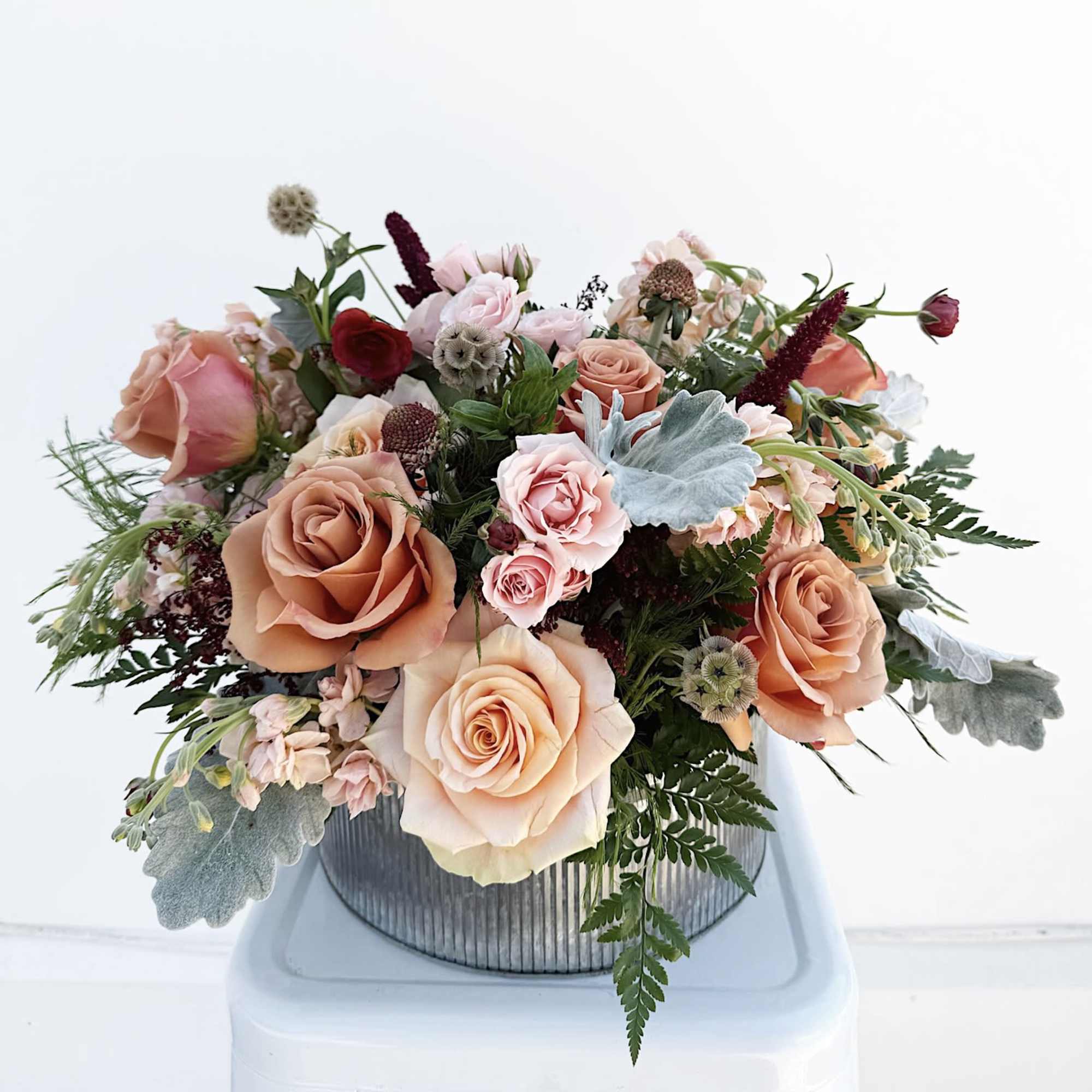 A charming, medium-sized arrangement bursting with sweet blooms and lush greenery in