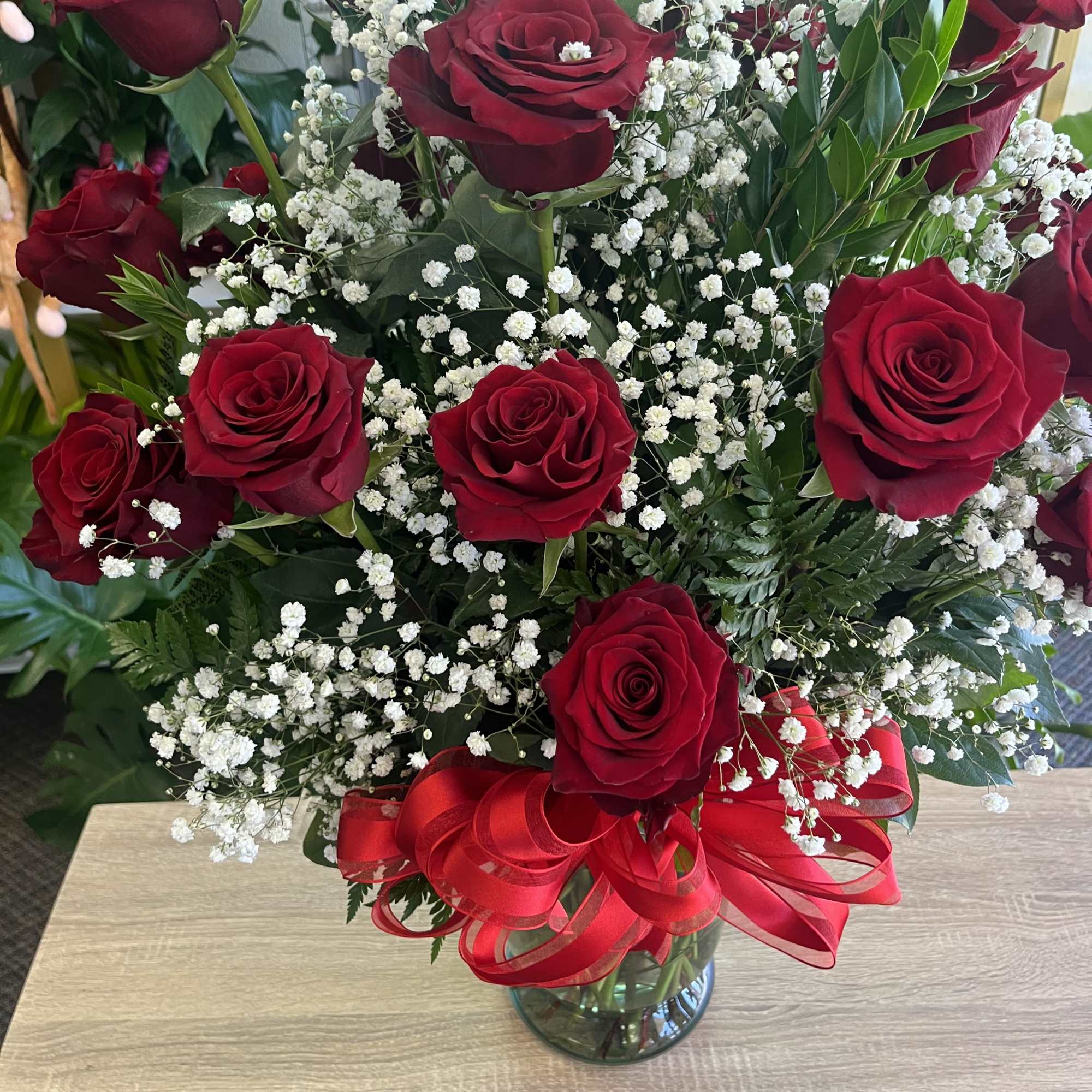 24 long red roses , with leather lemon leaves and baby breath