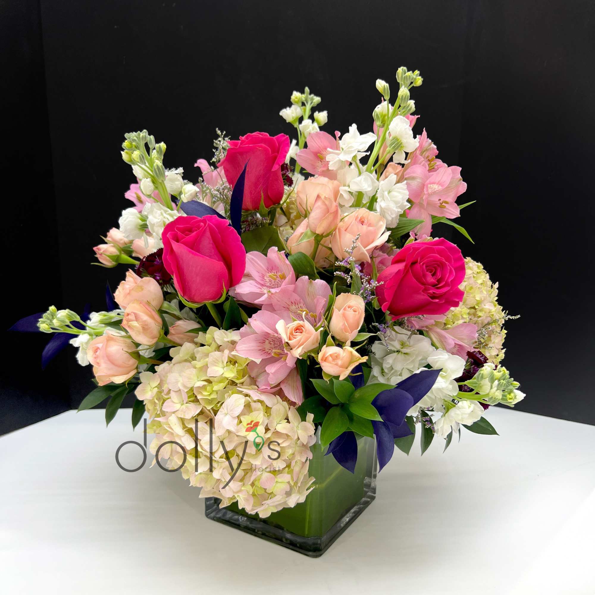 Highlights two shades of pink with roses and dianthus, accented by deep
