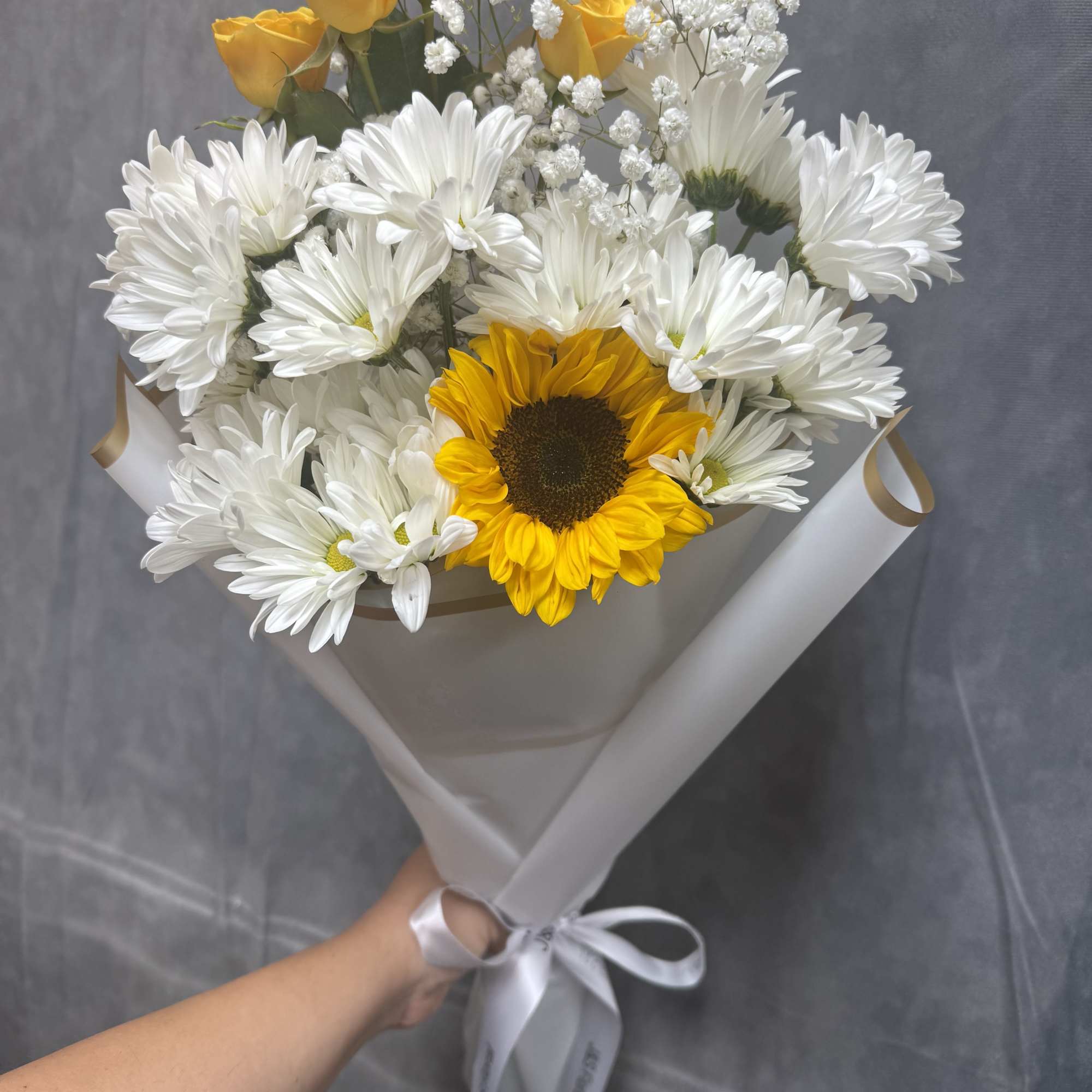A cheerful hand-tied bouquet of bright sunflowers and sweet white daisies &mdash;