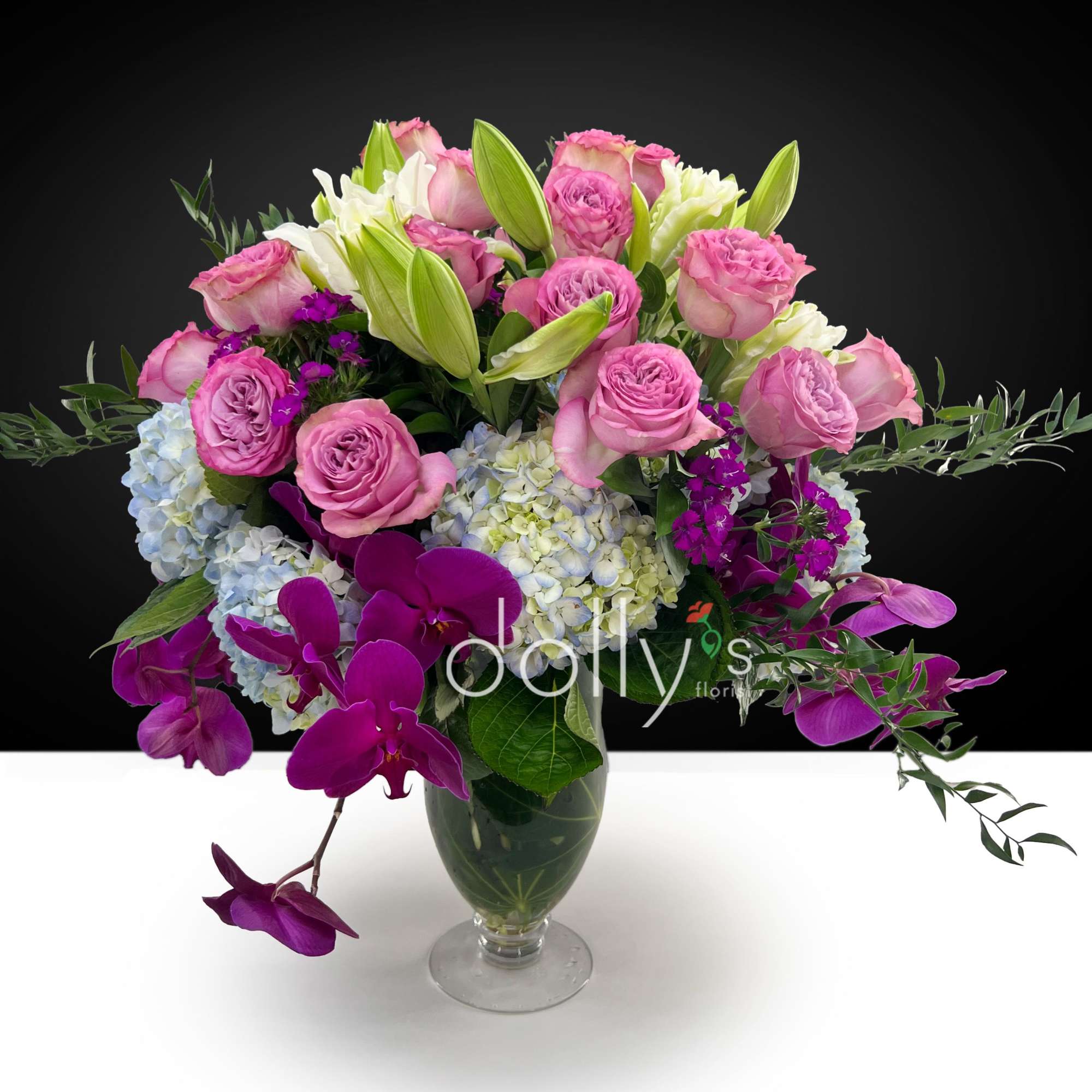 Featuring deep purple orchids, soft blue hydrangeas, and heirloom roses