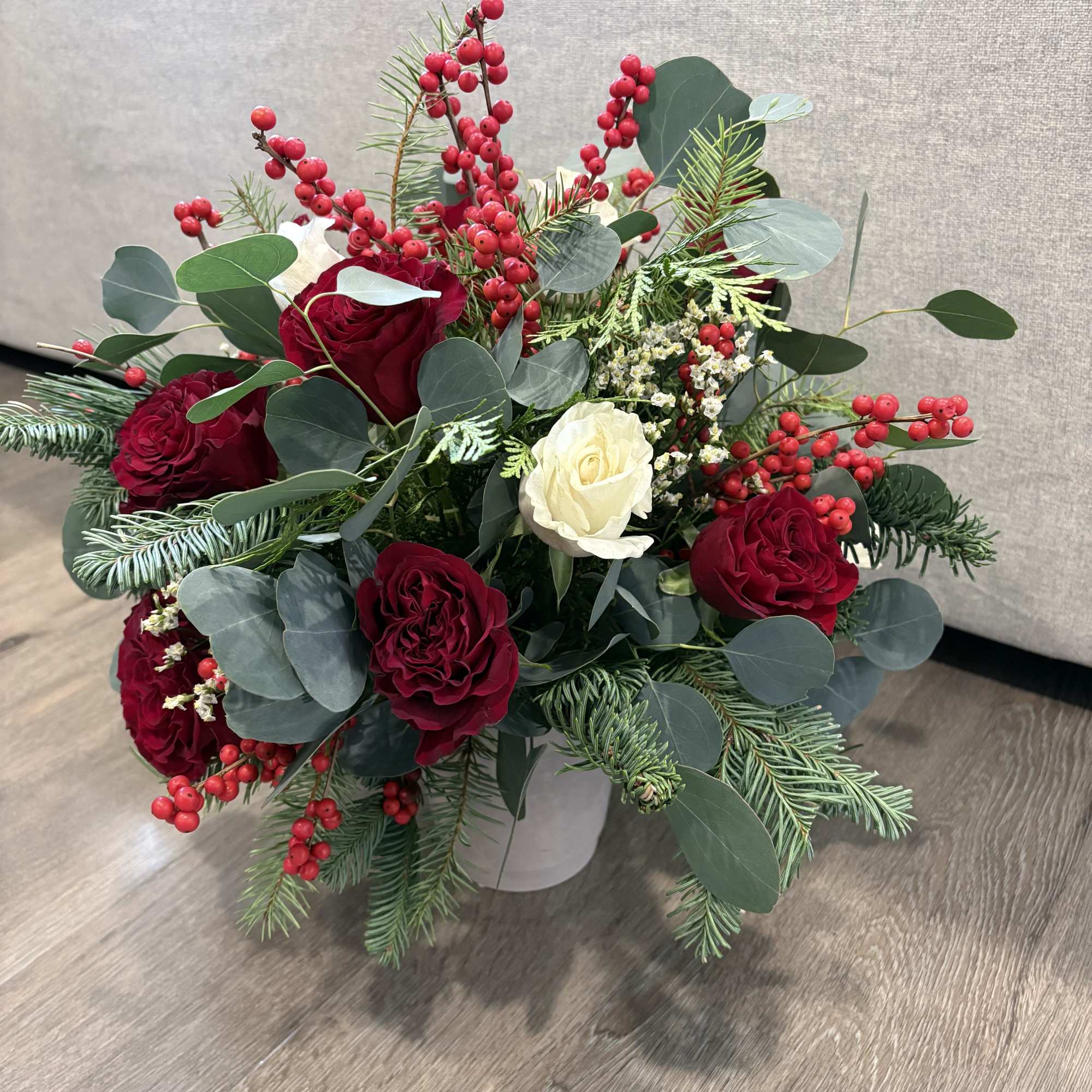 This beautifully arranged bouquet features vibrant red roses and white roses, surrounded