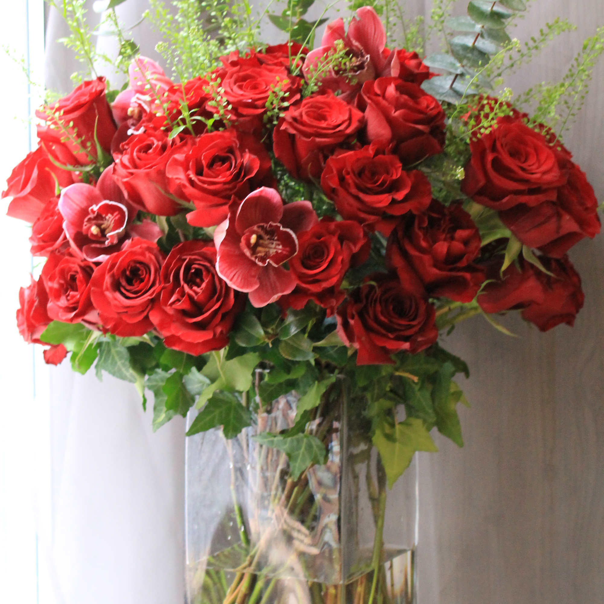 Gorgeous red long stem roses with ivy, orchids and pretty greenery. 
As
