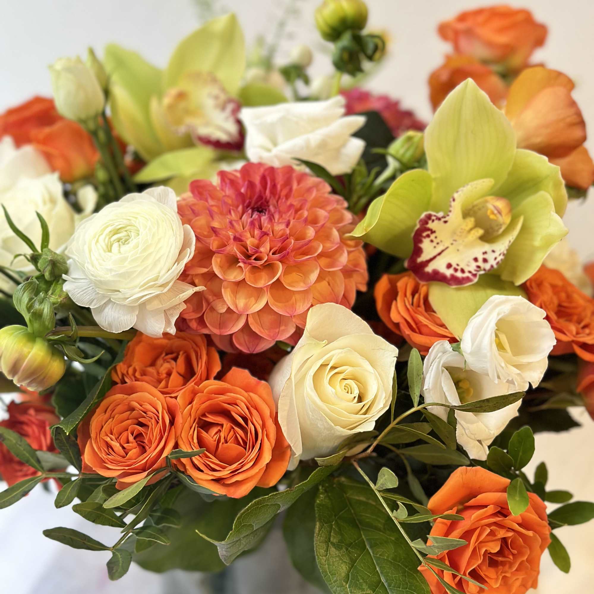 Summer crush! Orange roses, white lisianthus and dahlias with fresh summer greenery.