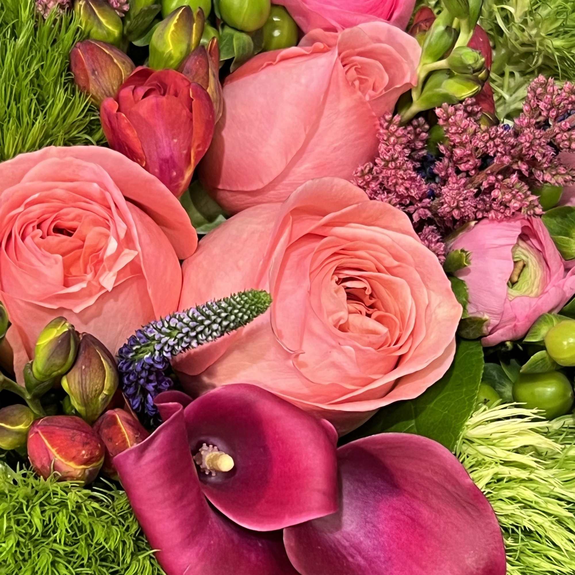 This exclusive romantic bouquet of different shapes of garden roses, ranunculus, calla
