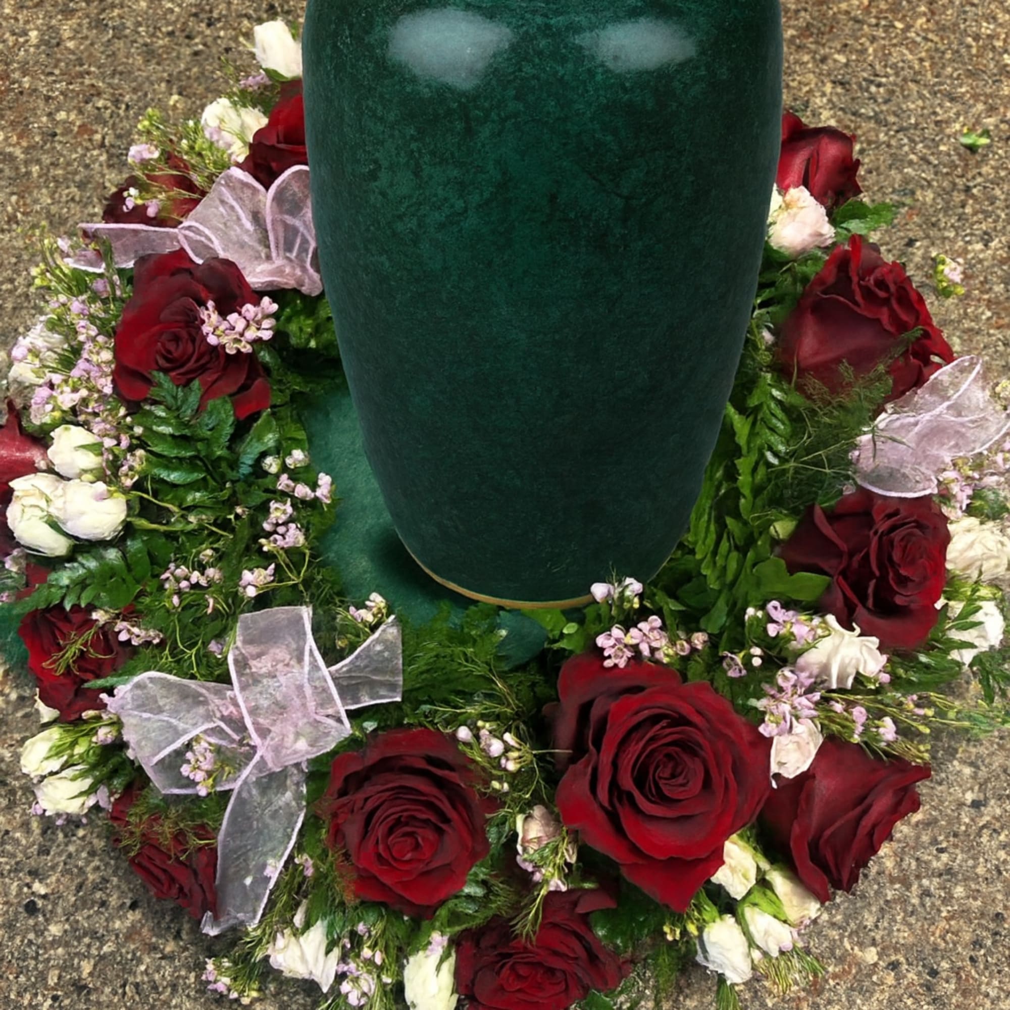Pure red roses and greenery come together to create this beautiful urn