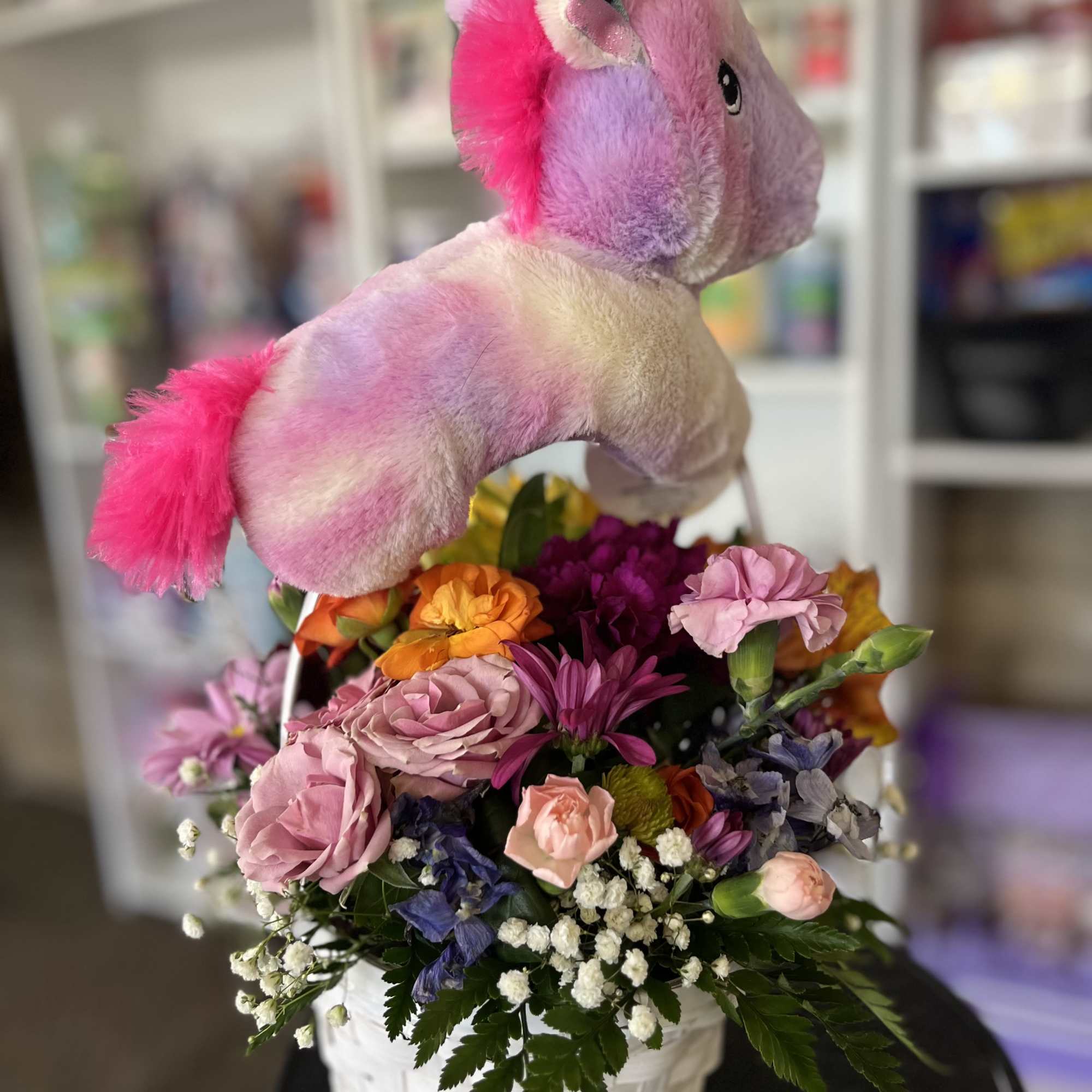 fresh flowers in basket with unicorn plush 
