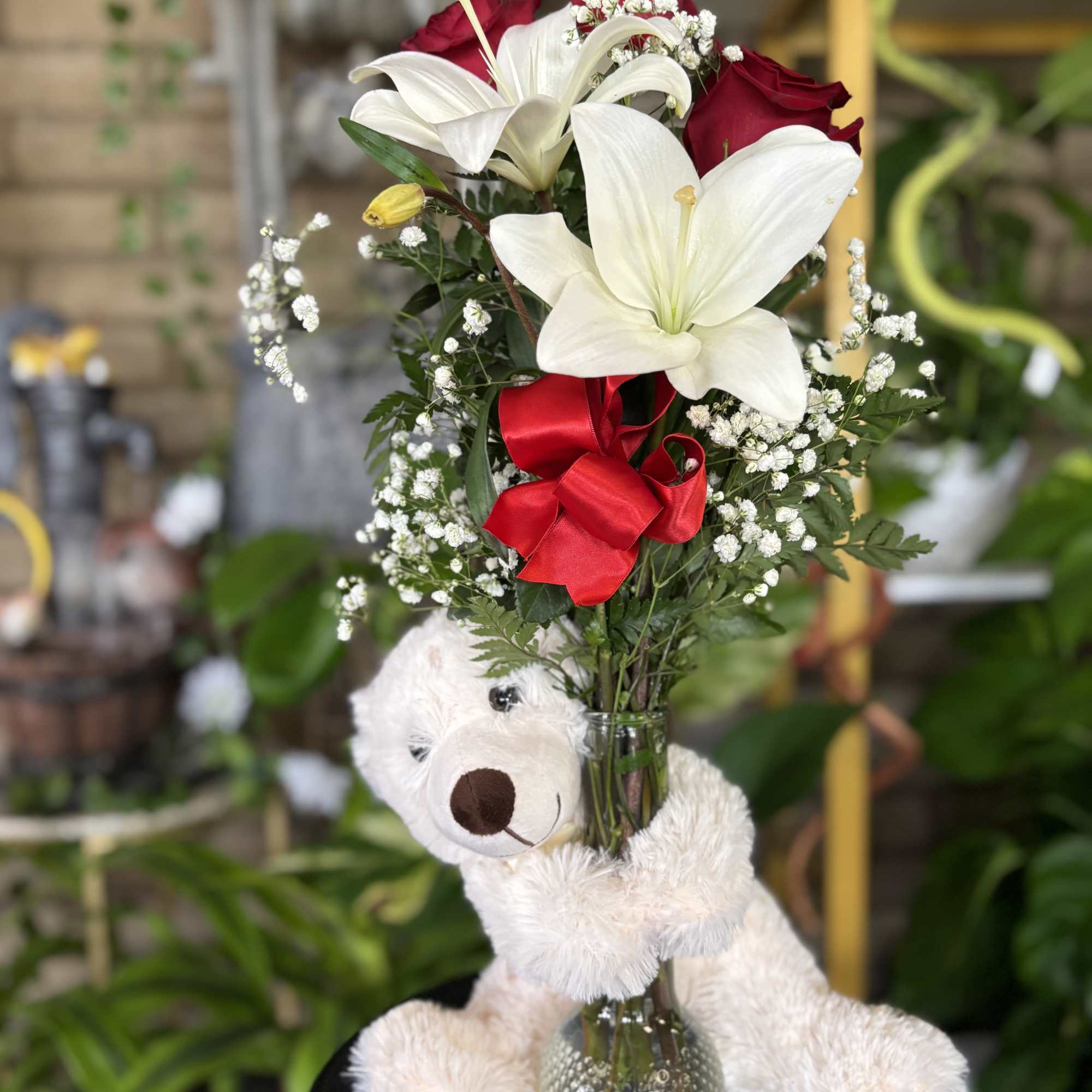 Three red roses and white lilies in bud base with large white