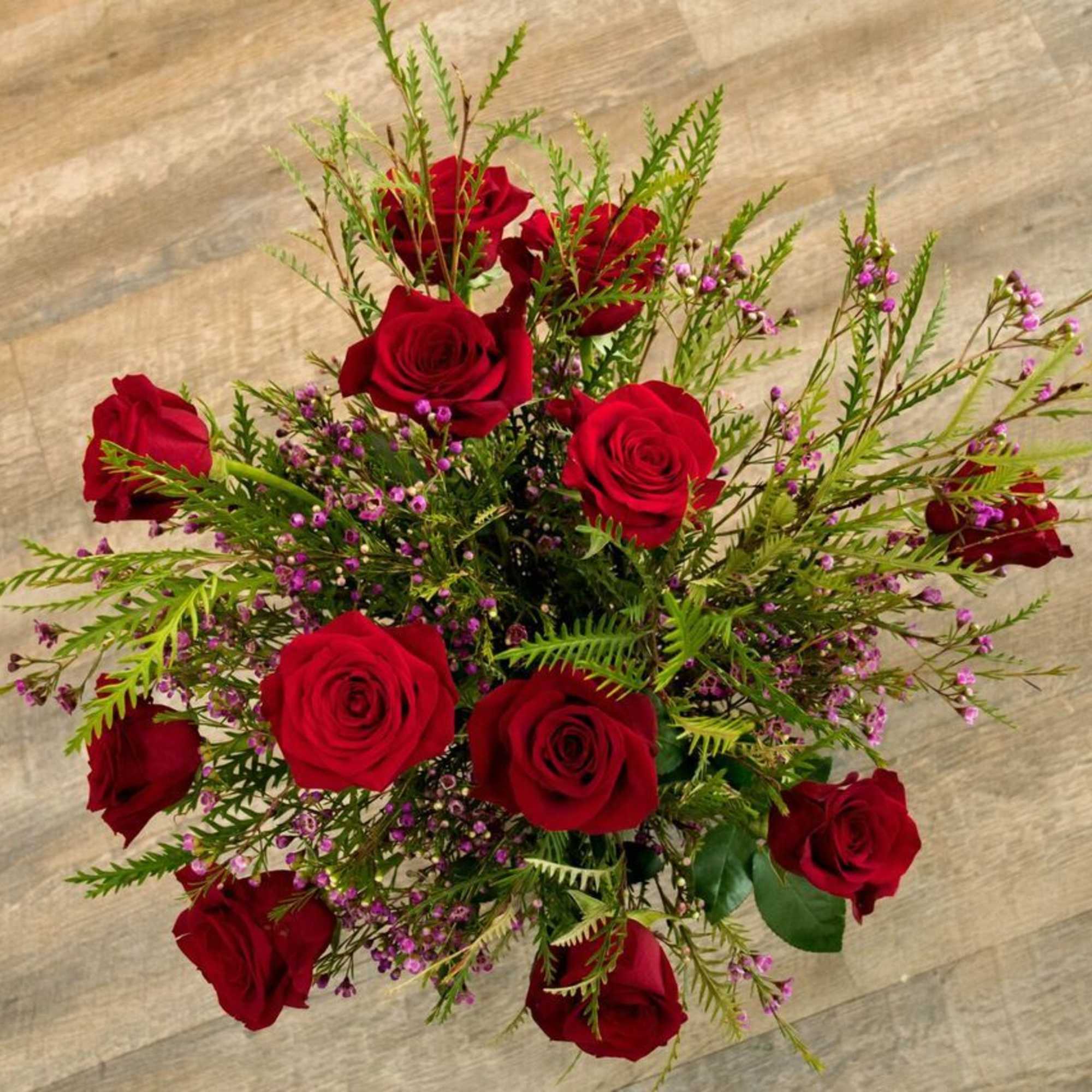  Dozen long stem roses with greens and beautiful wax flower. We