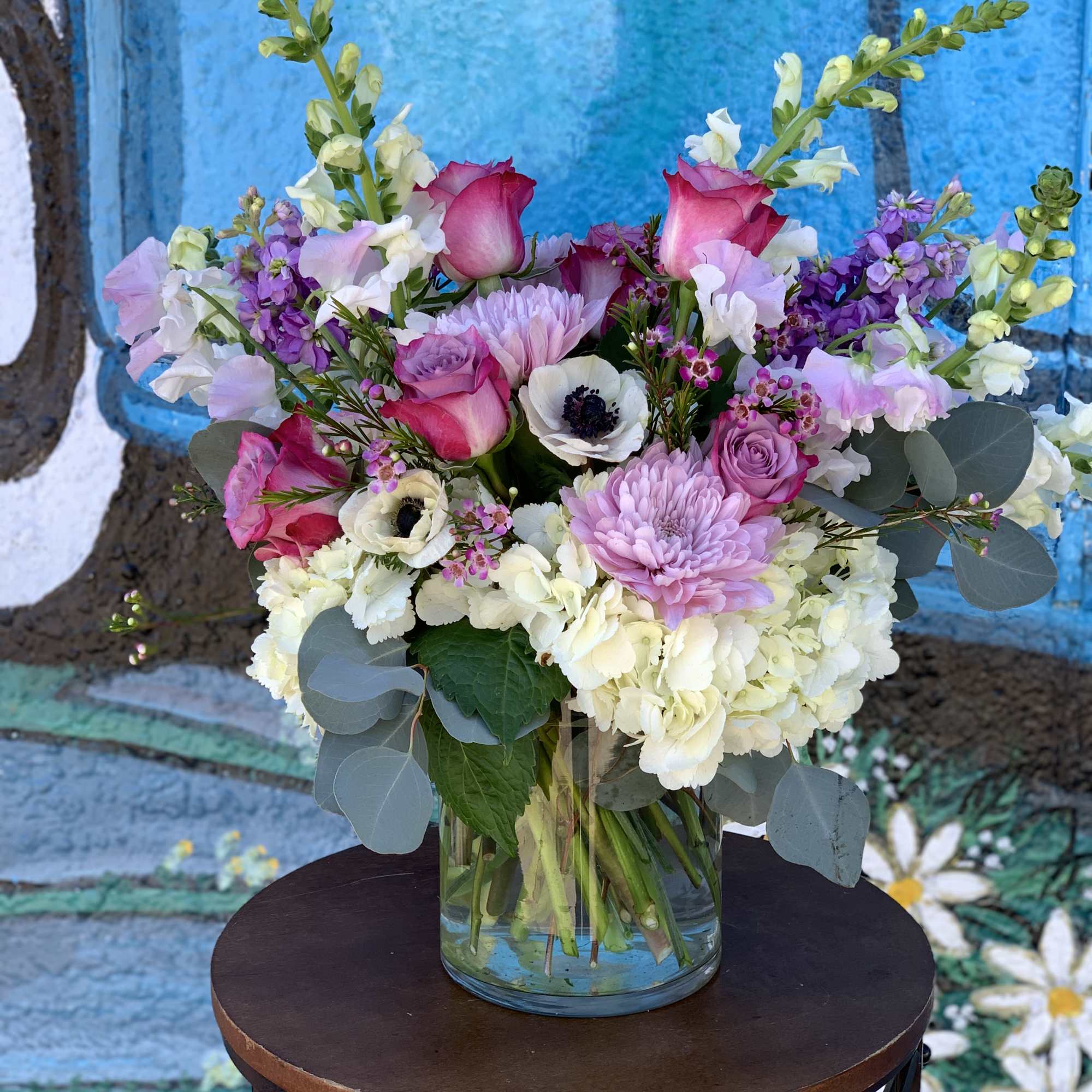 Seasonal pink, white and lavender flowers arranged in a vase. 
