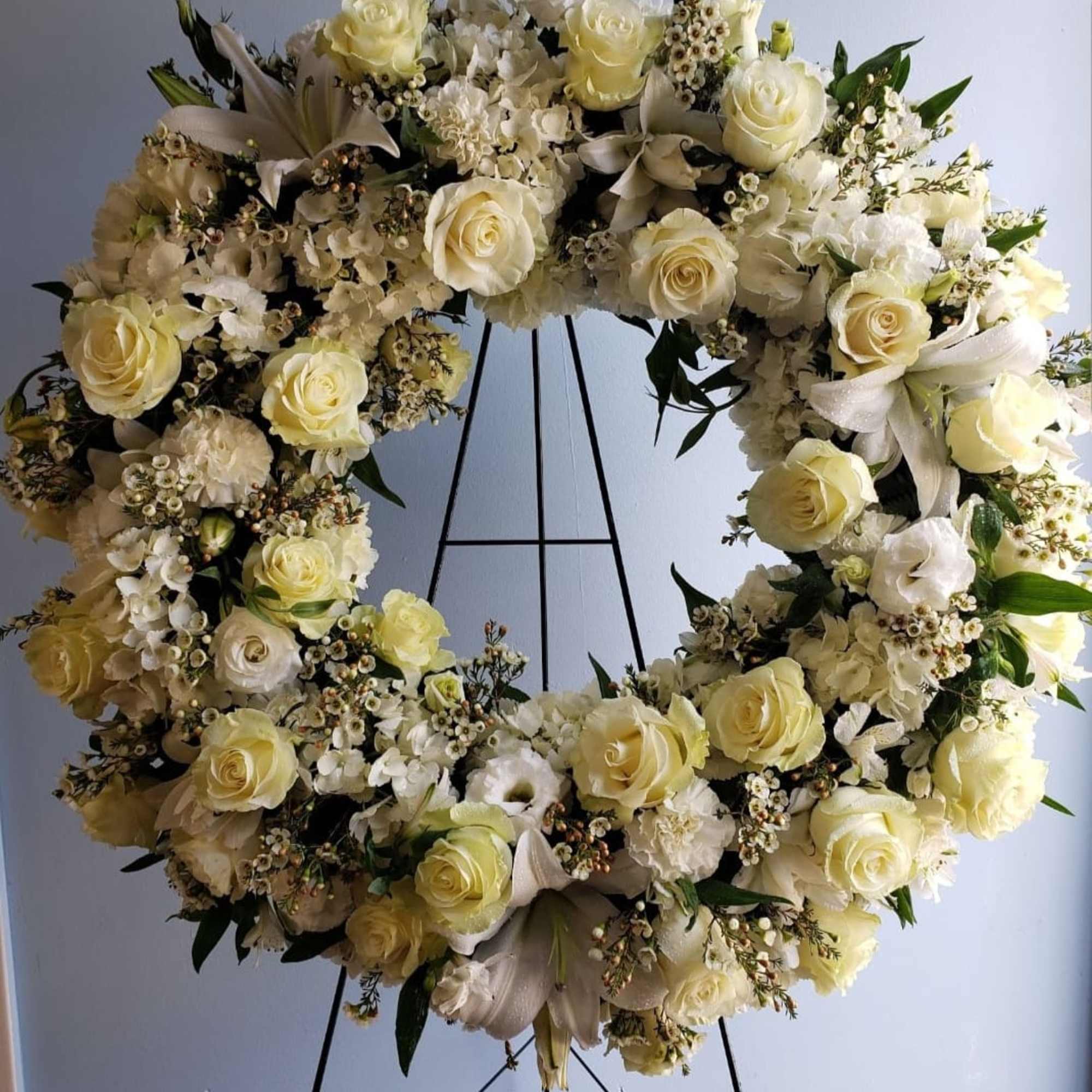 Traditional funeral wreath filled with seasons best white flowers such as roses