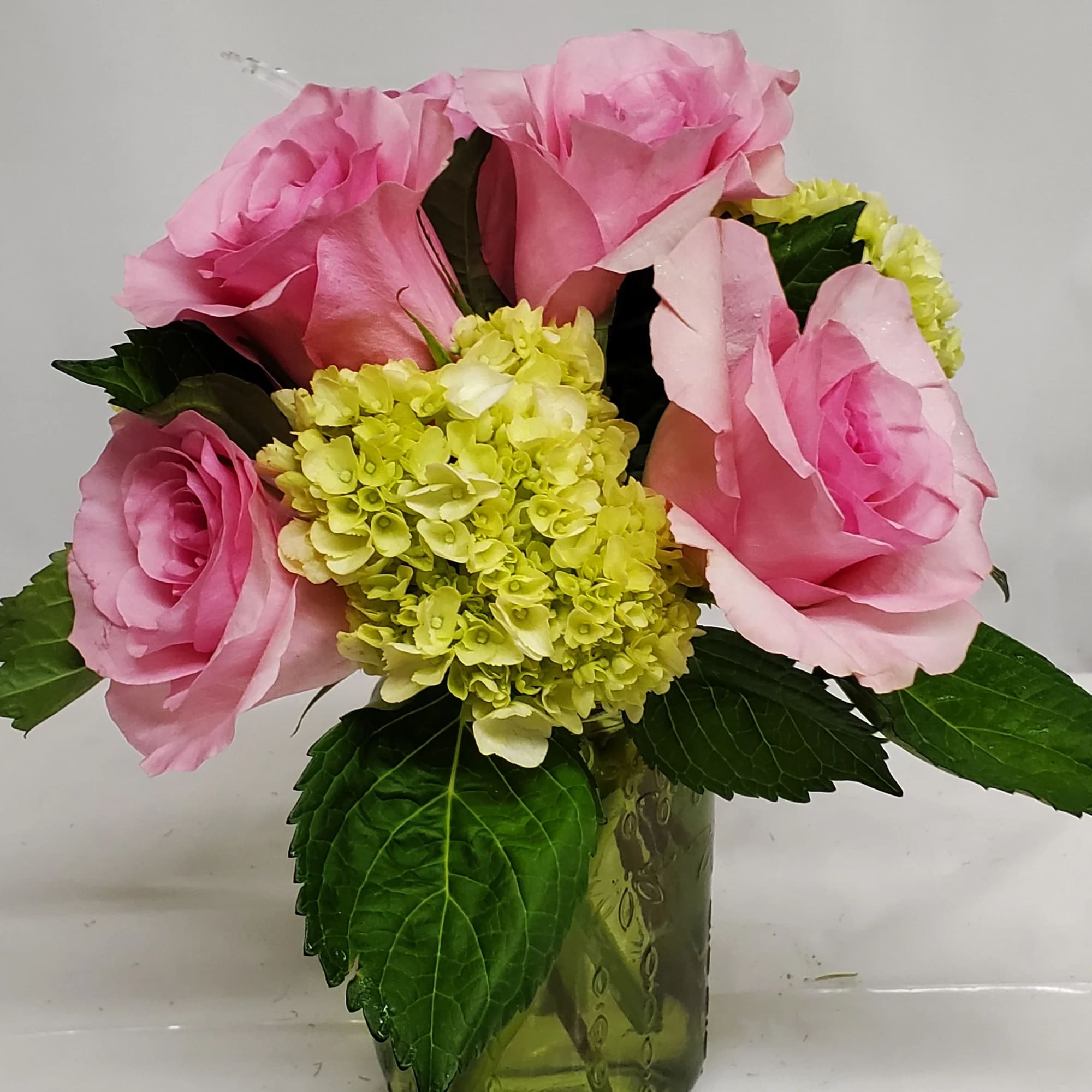 Green hydrangea &amp; pink roses in mason jar