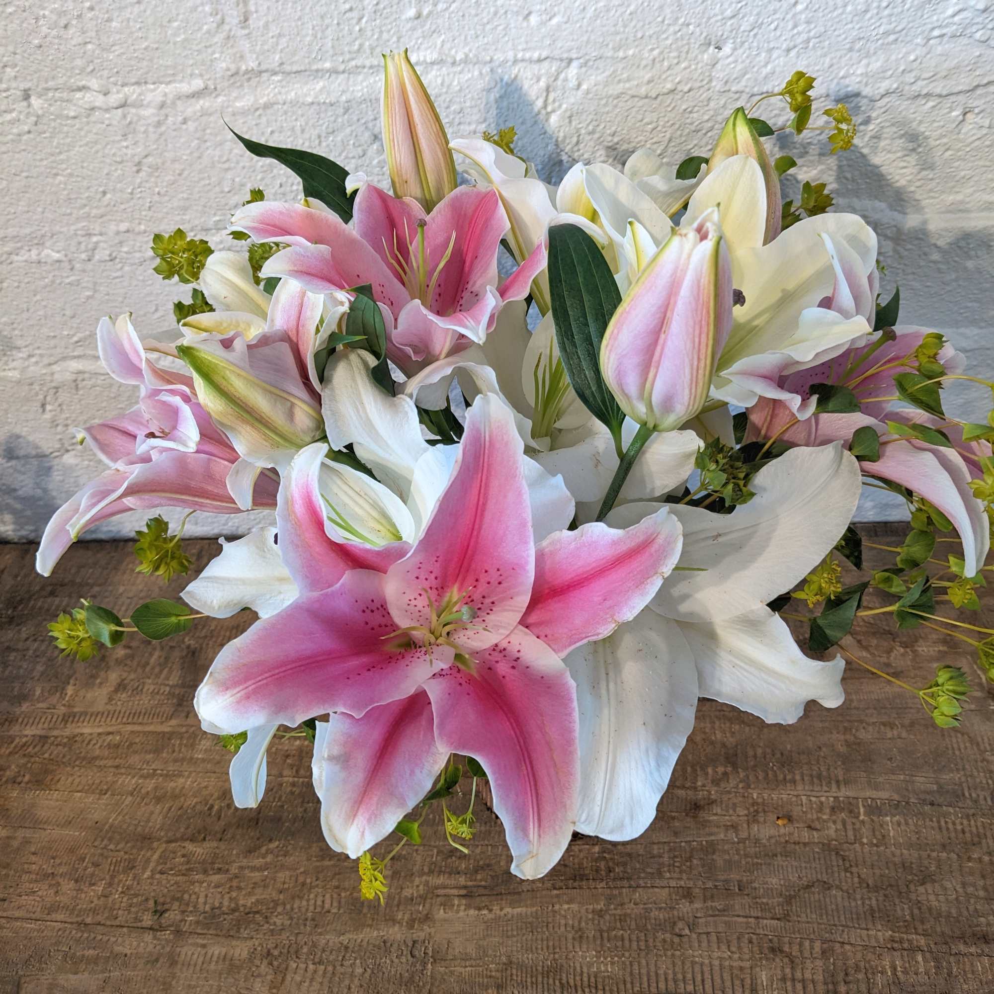 A mixture of Casablanca and stargazer lilies in a peach vase. Perfect