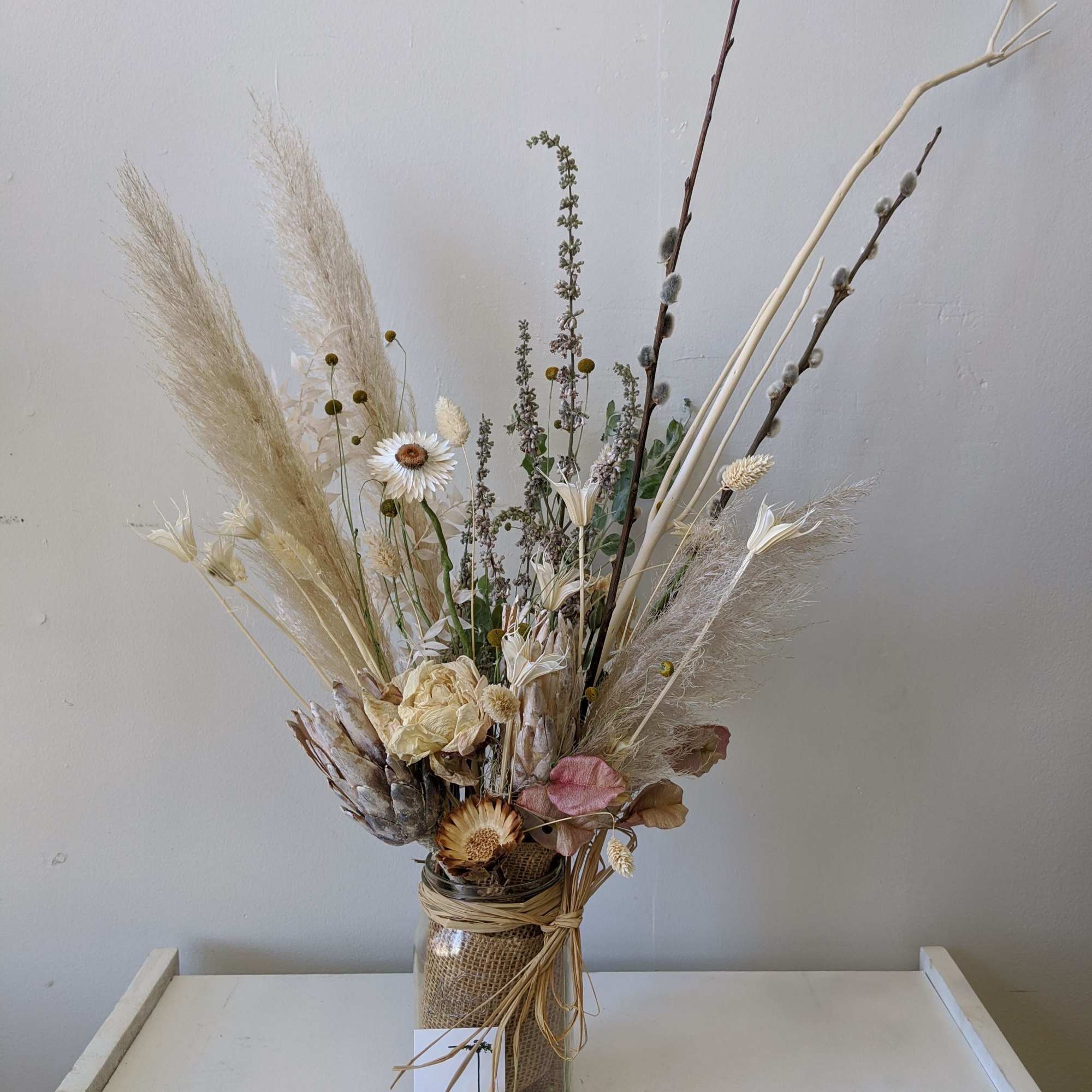 This everlasting dried arrangement includes dried Peonies and pampas and comes in