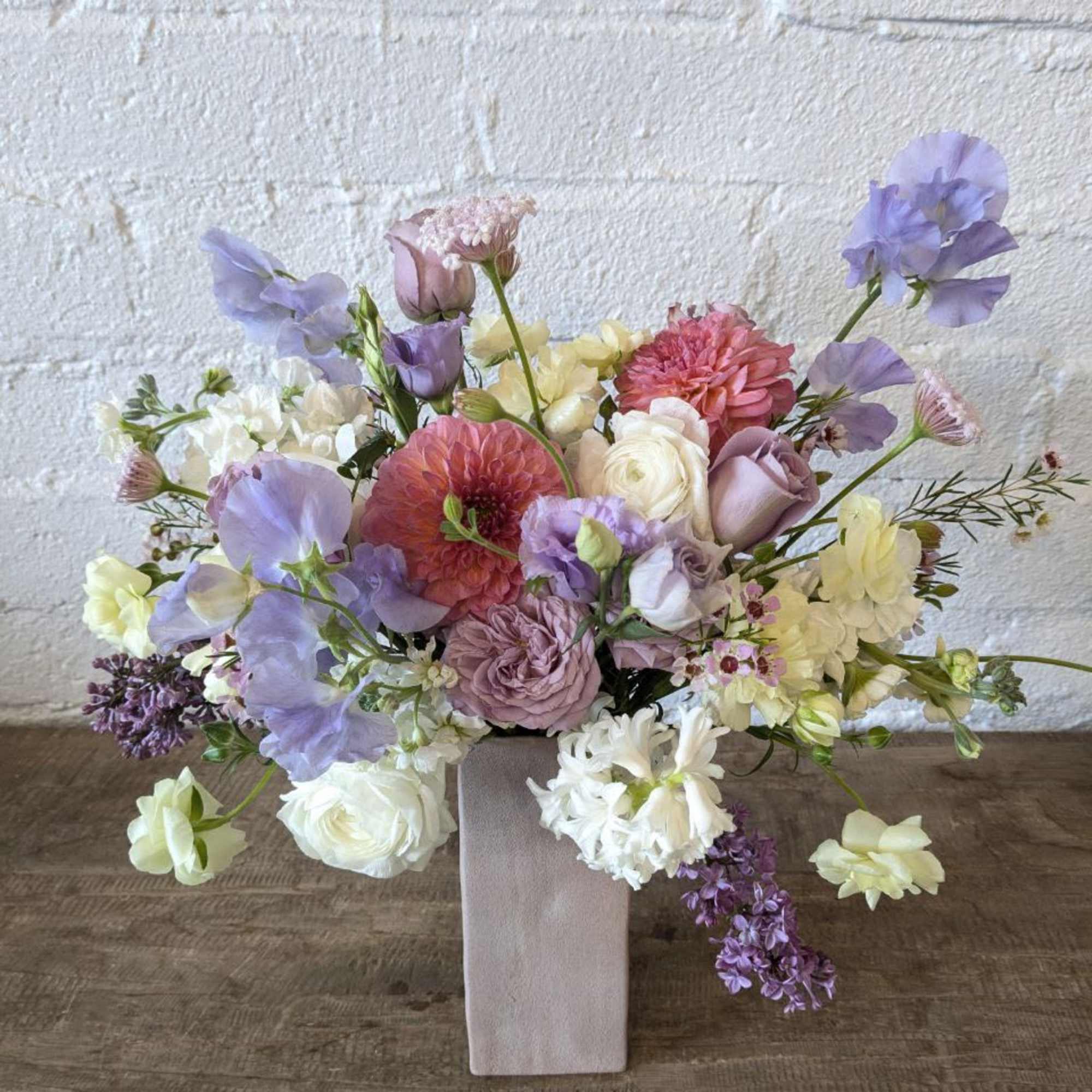 A subtle assortment of lavenders with a pop of peach in a