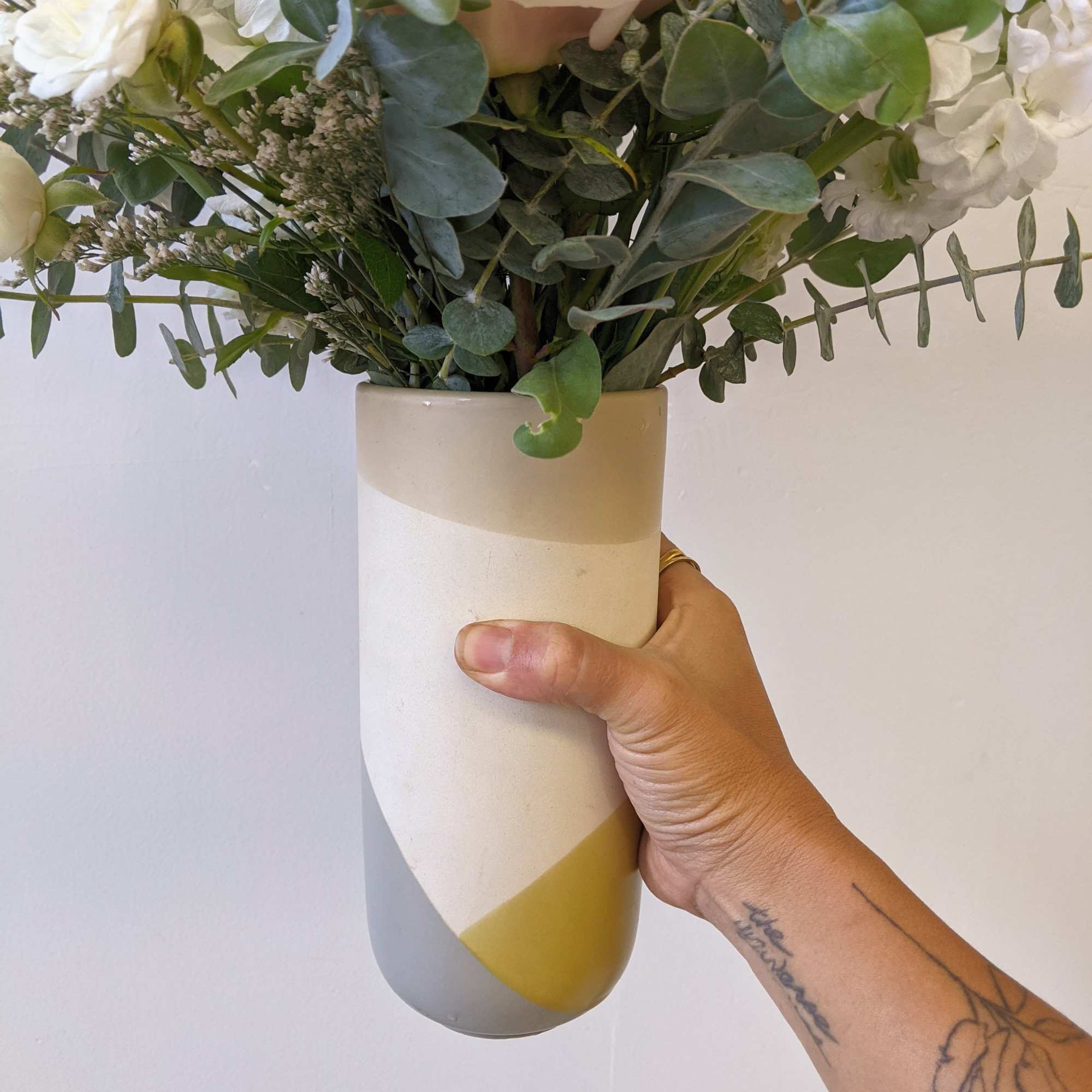 A monochromatic and neutral toned arrangement in a ceramic colorblock vase. 