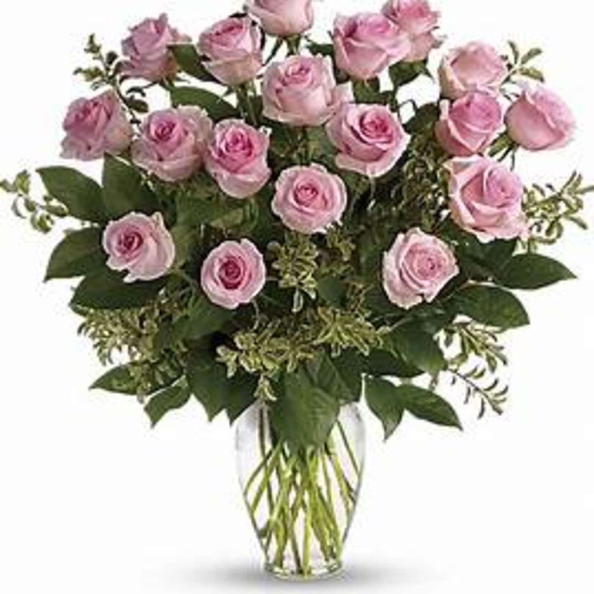 Dozen pink roses in a clear vase with beautiful greens. This is