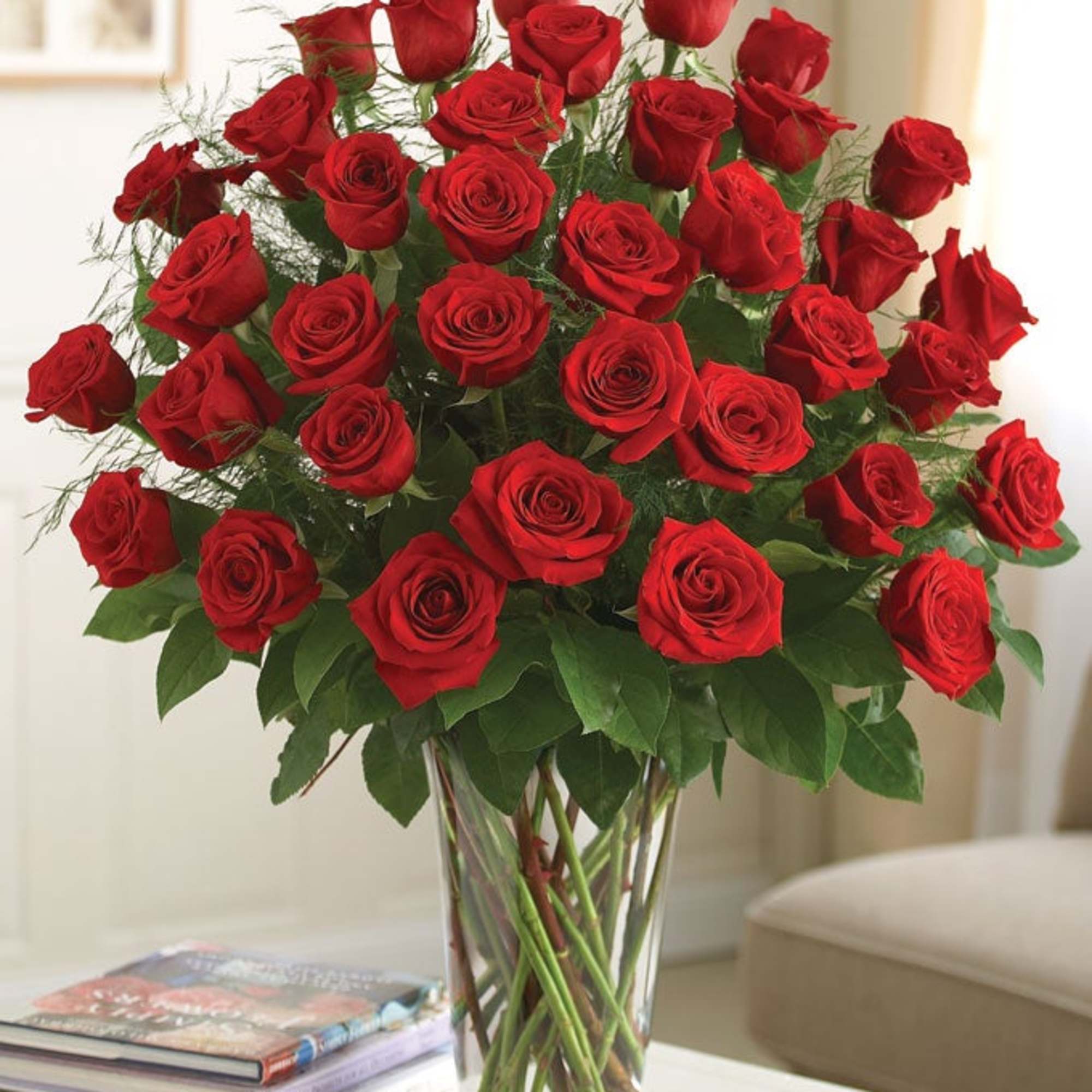 One dozen red roses in a clear vase with greenery. Great for