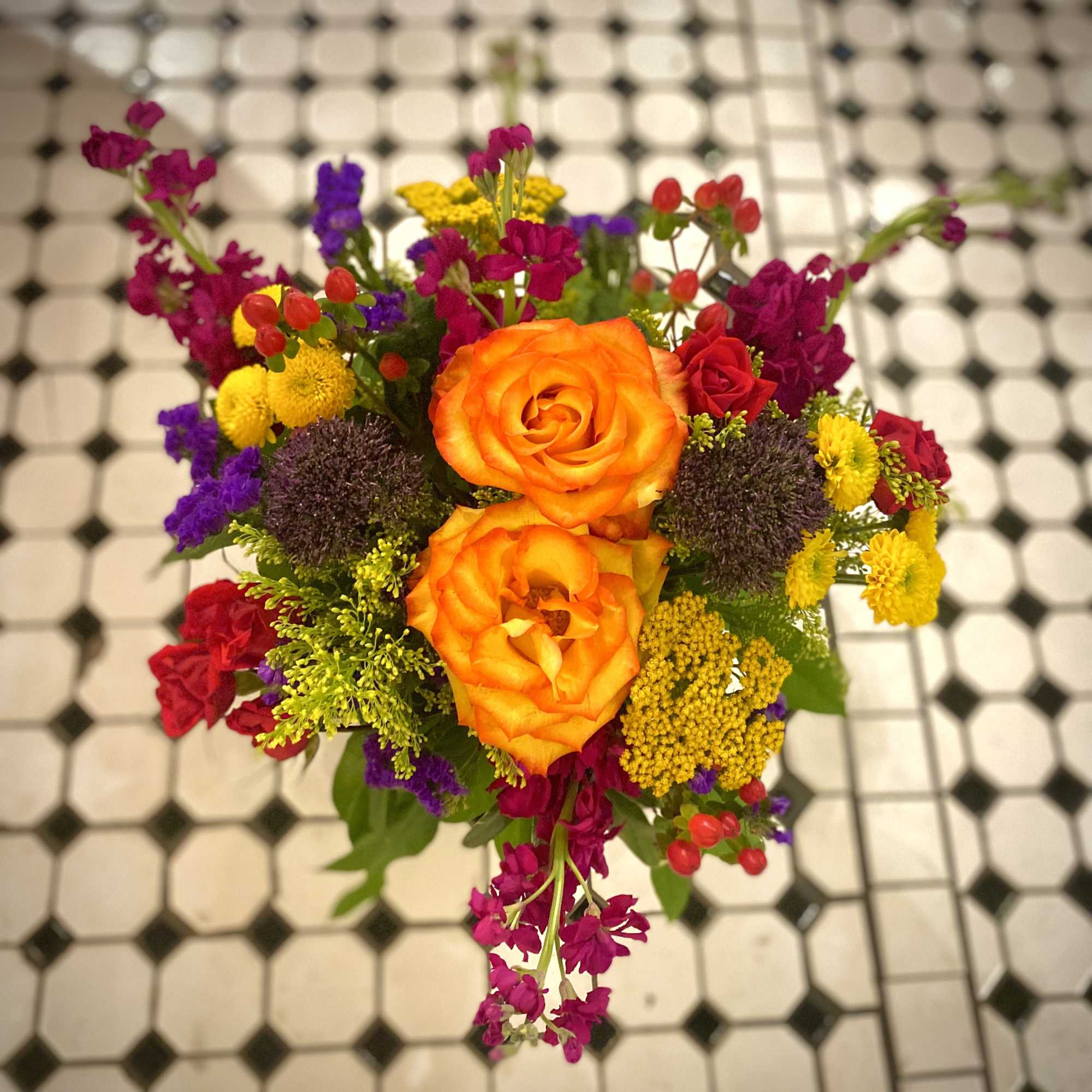 The Tuscan Sunset is a burst of bright colors: orange roses, fall