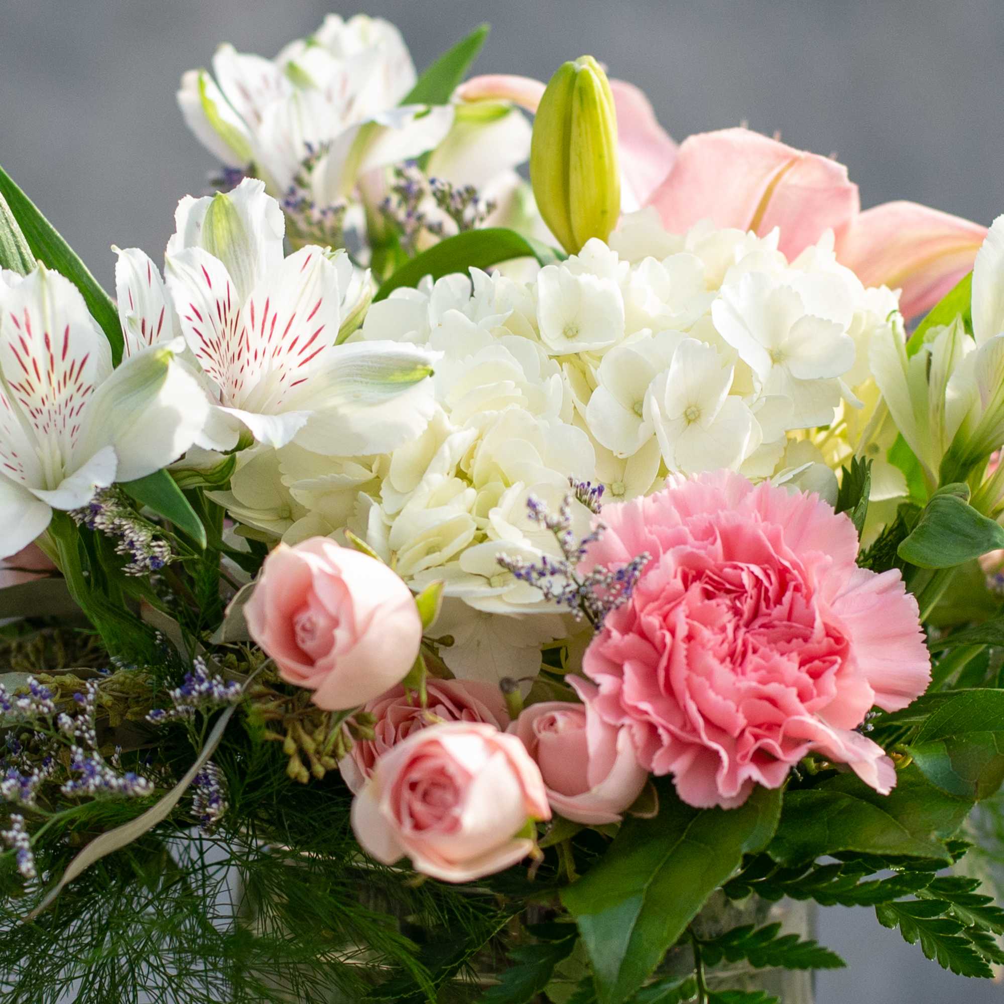 A delicate arrangement of pinks and whites in a 5" glass cylinder