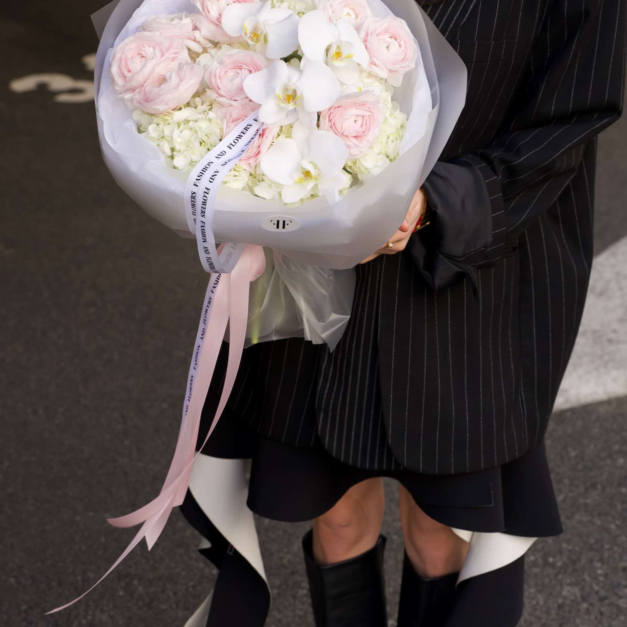 An airy couture-style bouquet featuring blush ranunculus, white phalaenopsis orchids, and soft
