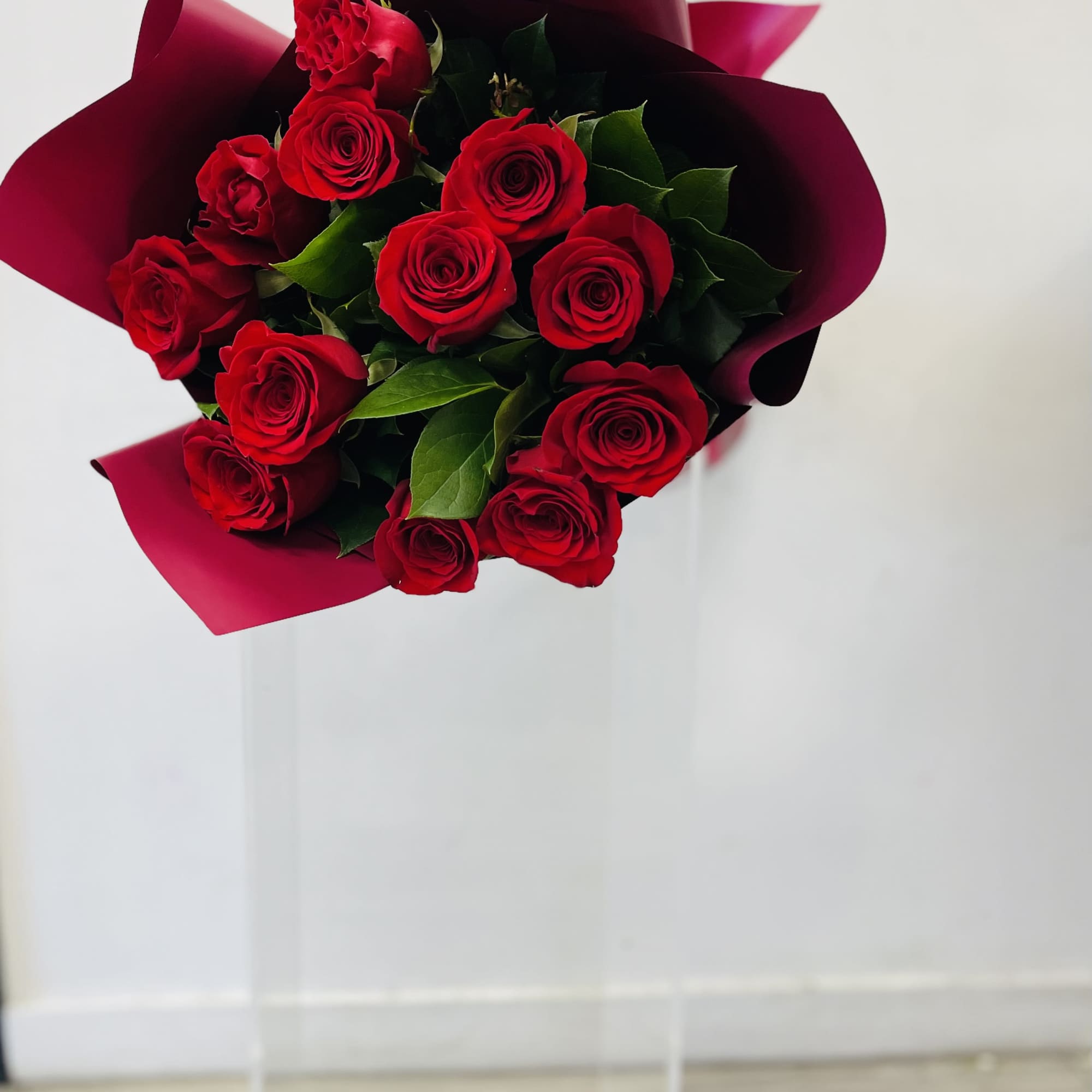12 Vibrant fresh red roses petit paired with exposed lush green leaves
