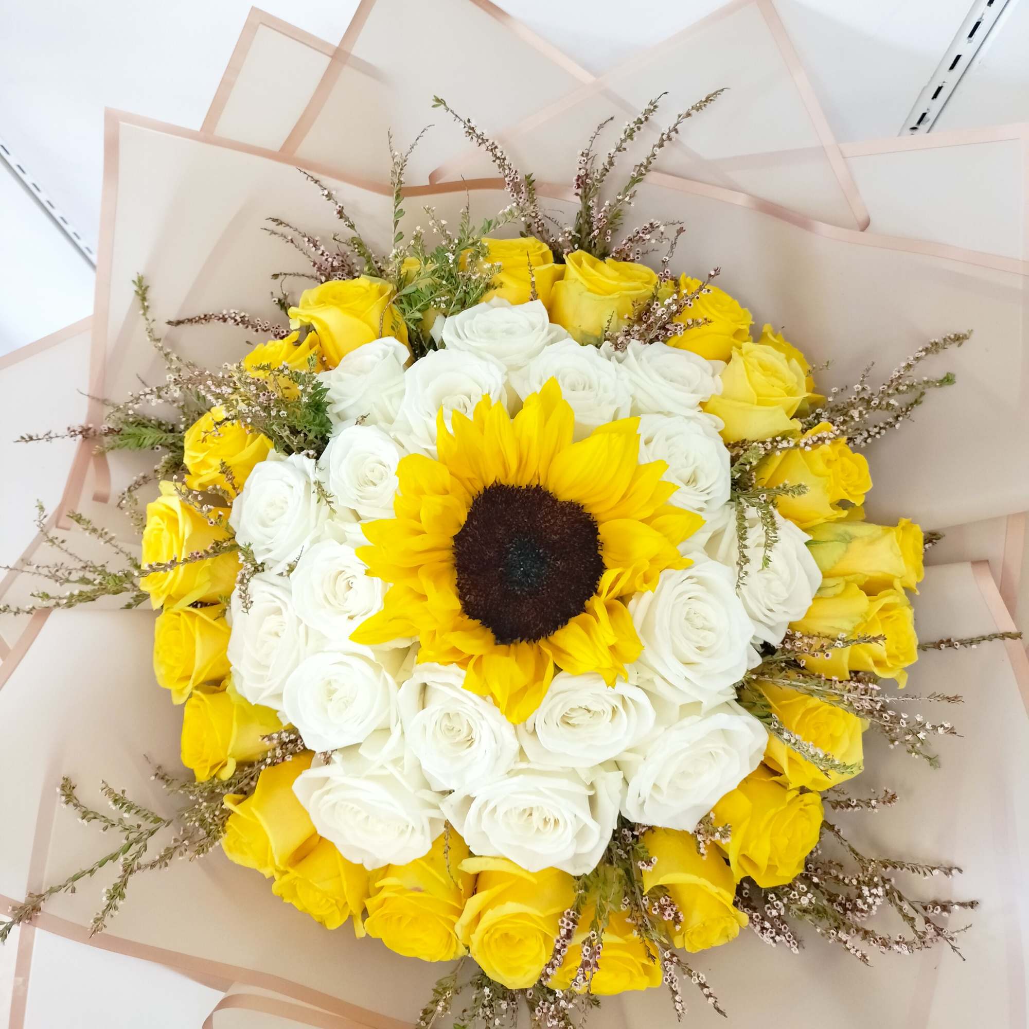 24 yellow roses, 24 white roses, 1 sunflower, and limonium, wrap light