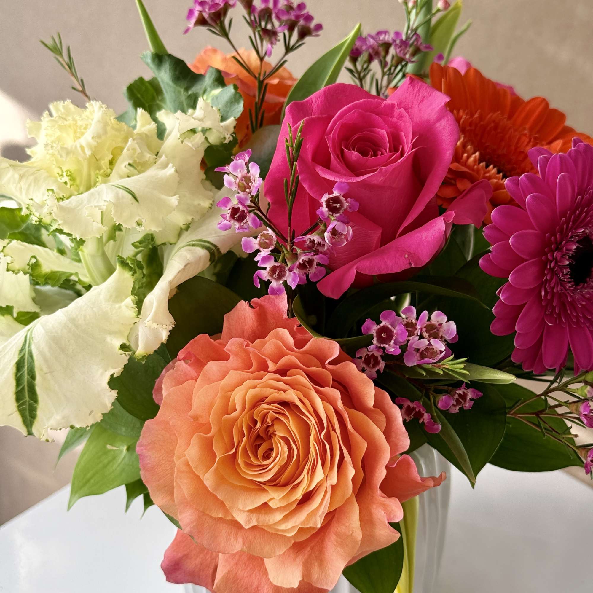 Spring with Tulips, Kale, Roses and Gerbera Daisies arranged in a ceramic