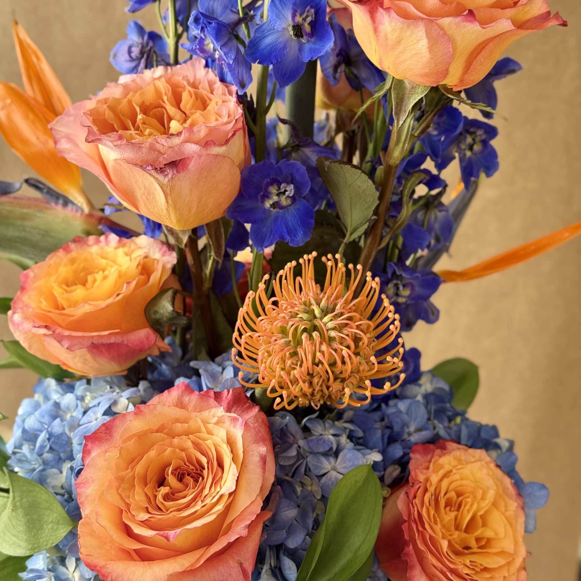 Blue and orange with Birds of Paradise, Hydrangeas, Delphinium and Roses arranged